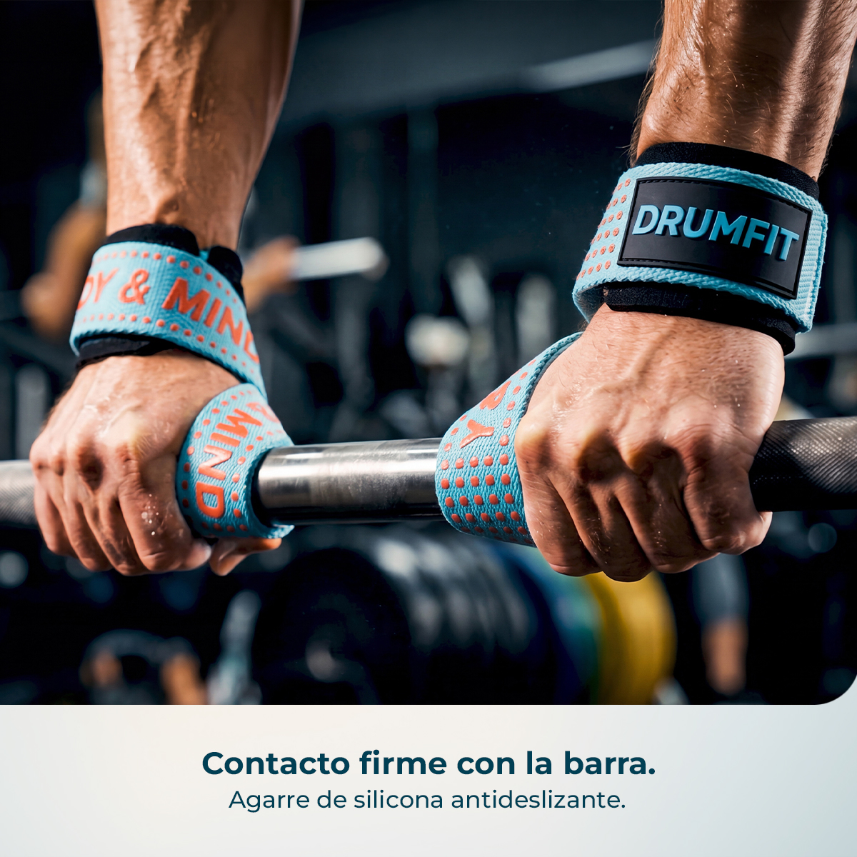 Manos musculosas agarrando una barra con correas de levantamiento azules y naranjas en un gimnasio.