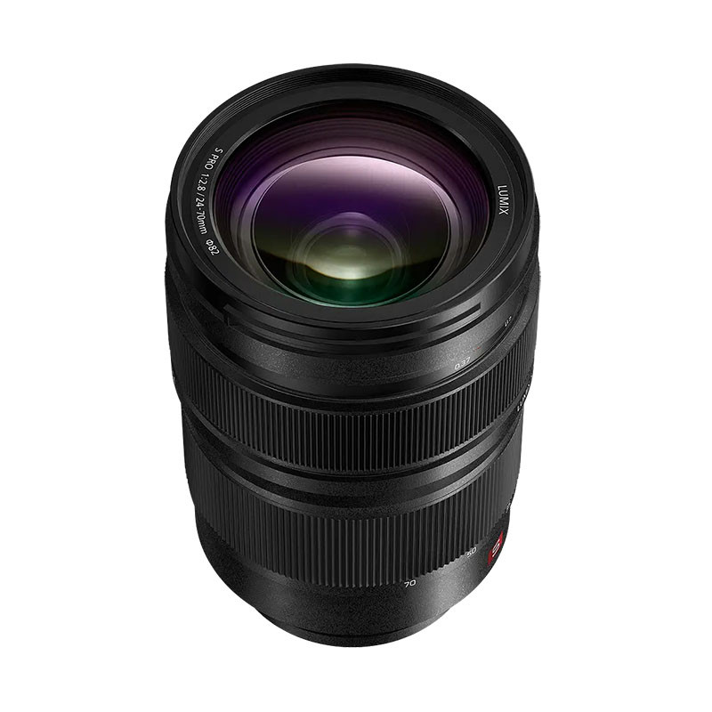 Ein schwarzes Lumix-Kamera-Zoomobjektiv steht senkrecht vor weißem Hintergrund, mit strukturierten Fokus- und Zoomringen.