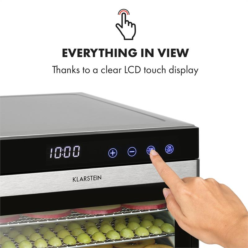 Mano che preme il display touch LCD di un essiccatore Klarstein con frutta verde.