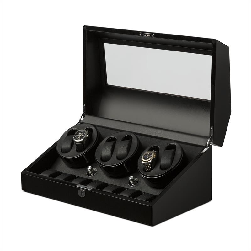 Scatola nera per orologi con coperchio in vetro e tre orologi automatici sui supporti.