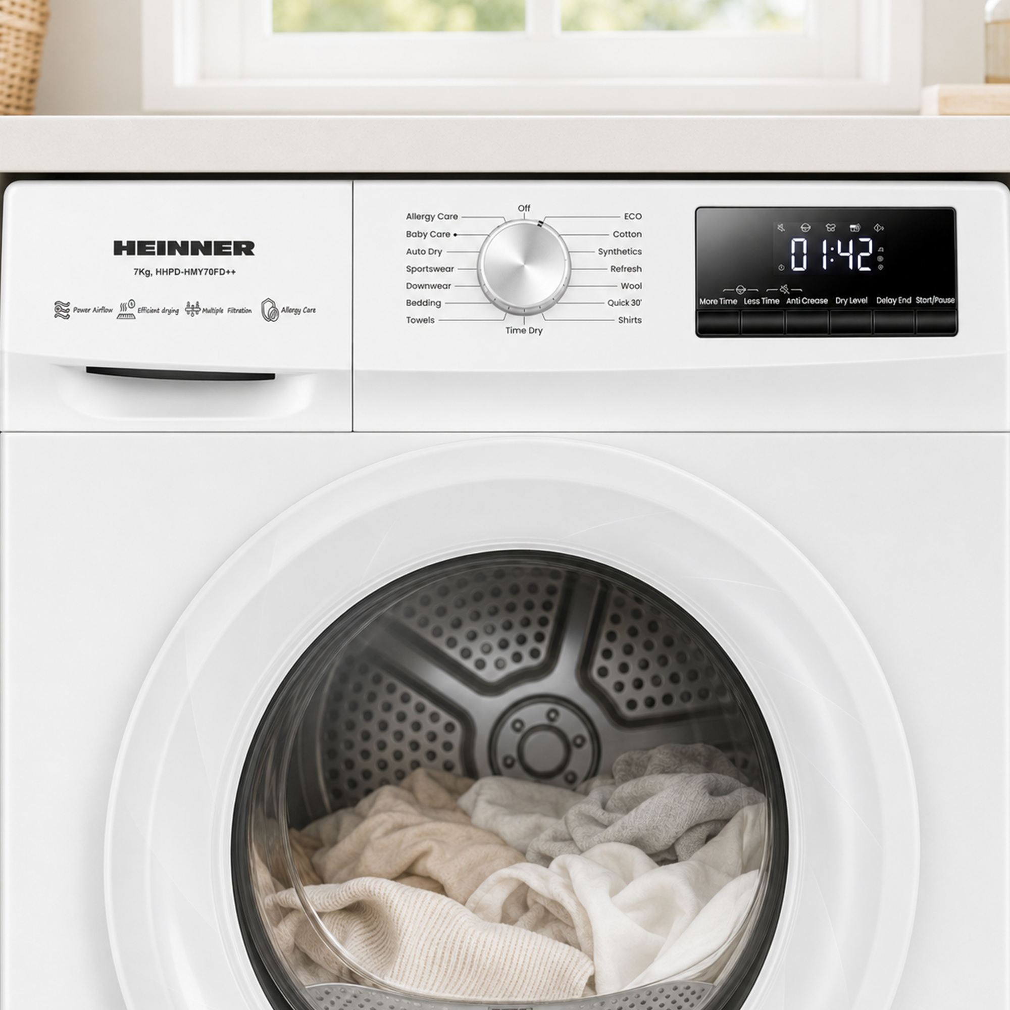 Witte Heinner wasdroger met digitaal display en kleding in de trommel.