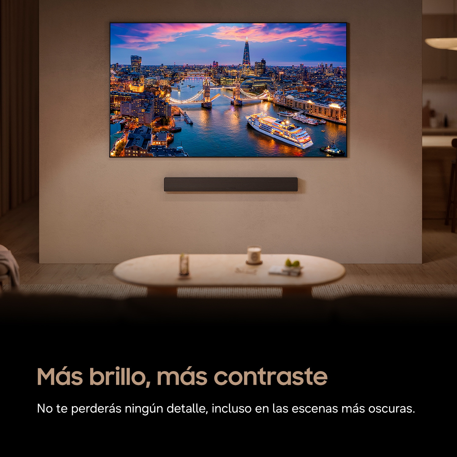 Una TV a parete mostra lo skyline al tramonto, con una soundbar sotto e un tavolino da caffè in primo piano.