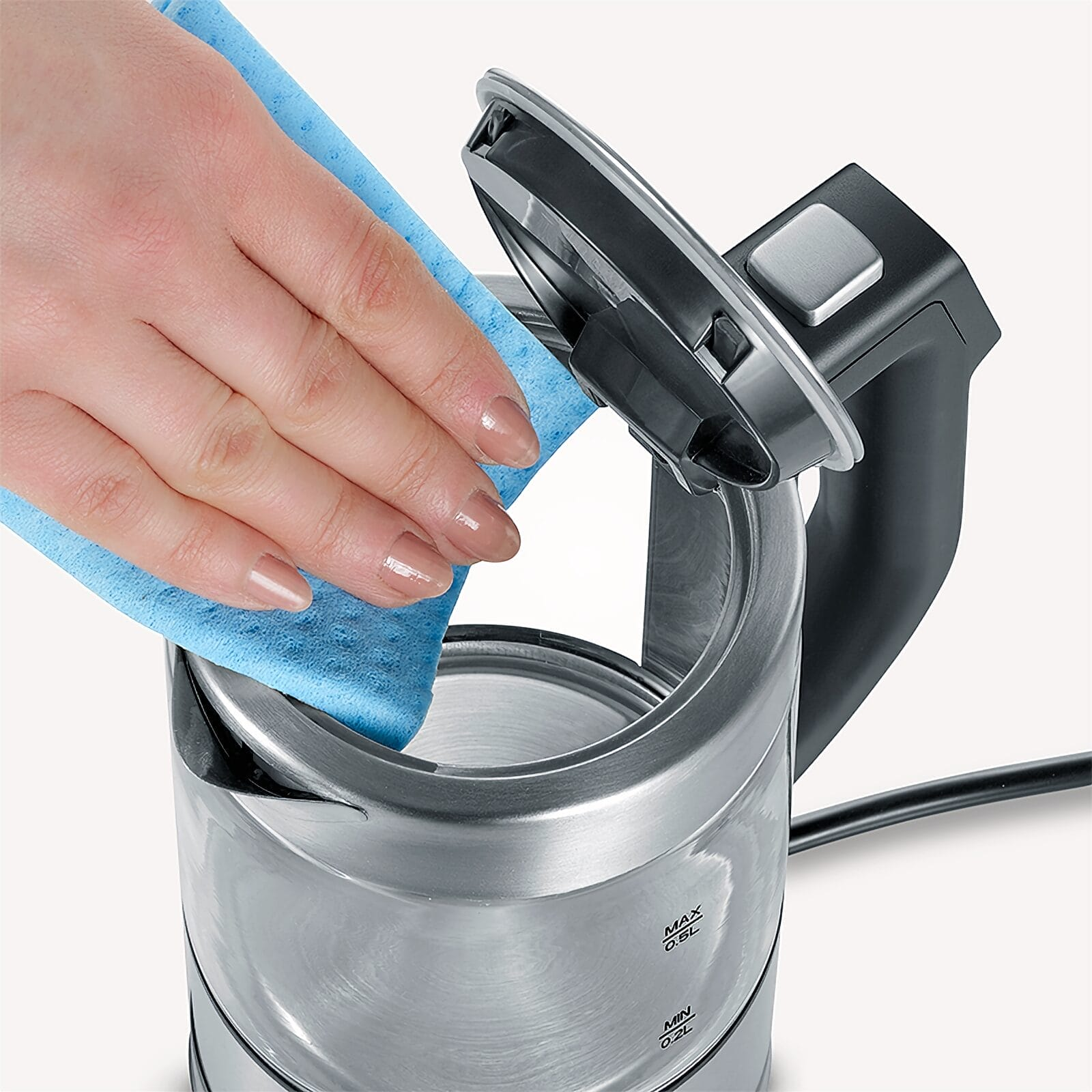 Een hand veegt de rand van een open roestvrijstalen waterkoker af met een blauwe doek.
