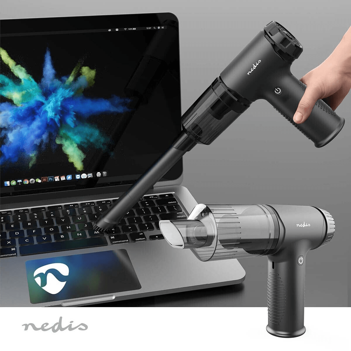 Una mano tiene un mini aspirapolvere nero che pulisce la tastiera di un computer portatile.