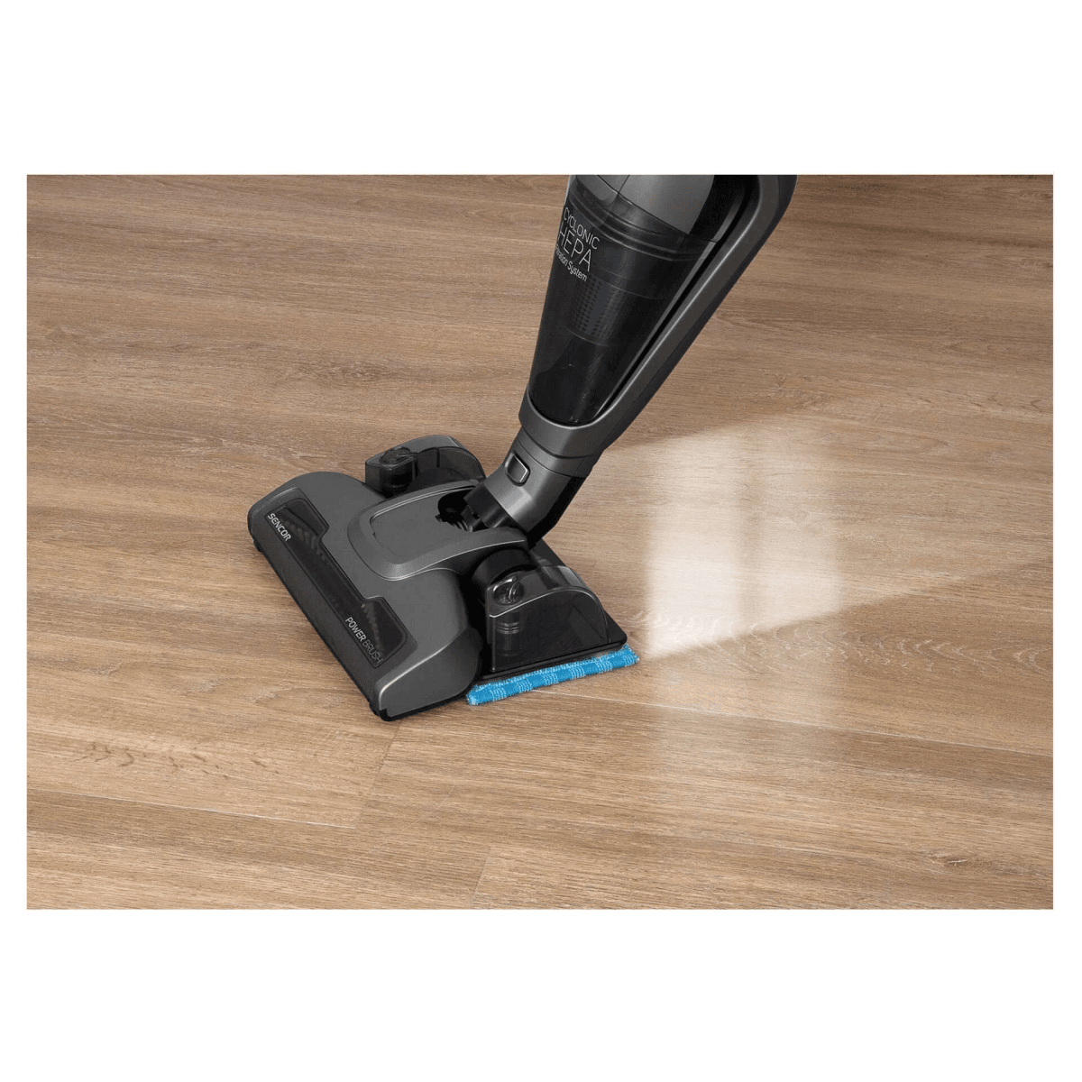 Un aspirapolvere grigio con un accessorio per mocio blu pulisce un pavimento in legno.