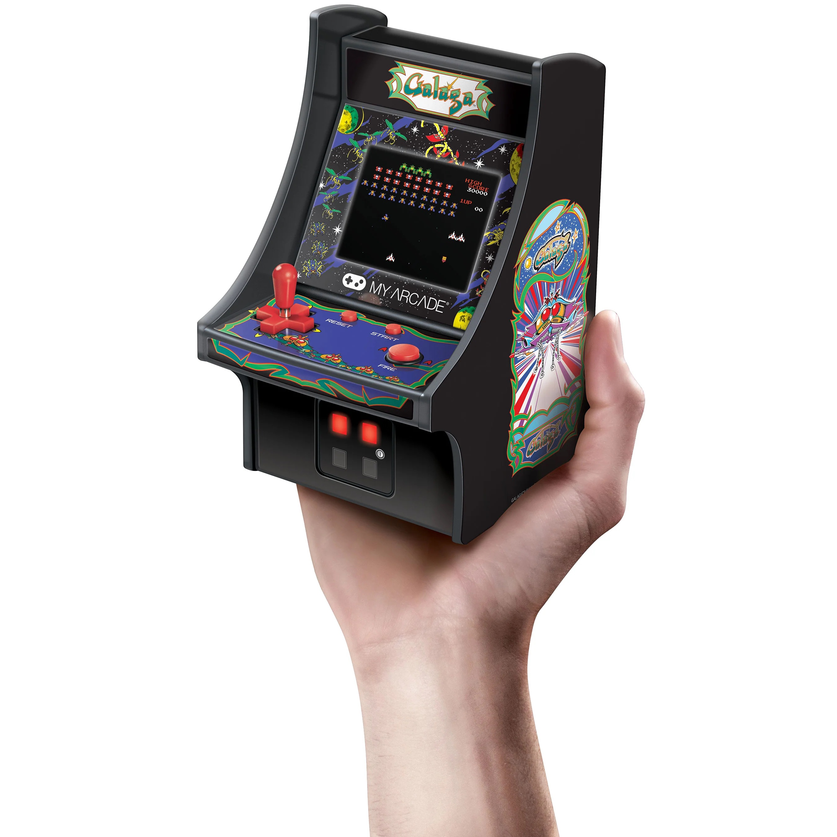 Una mano tiene una piccola console arcade Galaga nera con joystick e pulsanti rossi.
