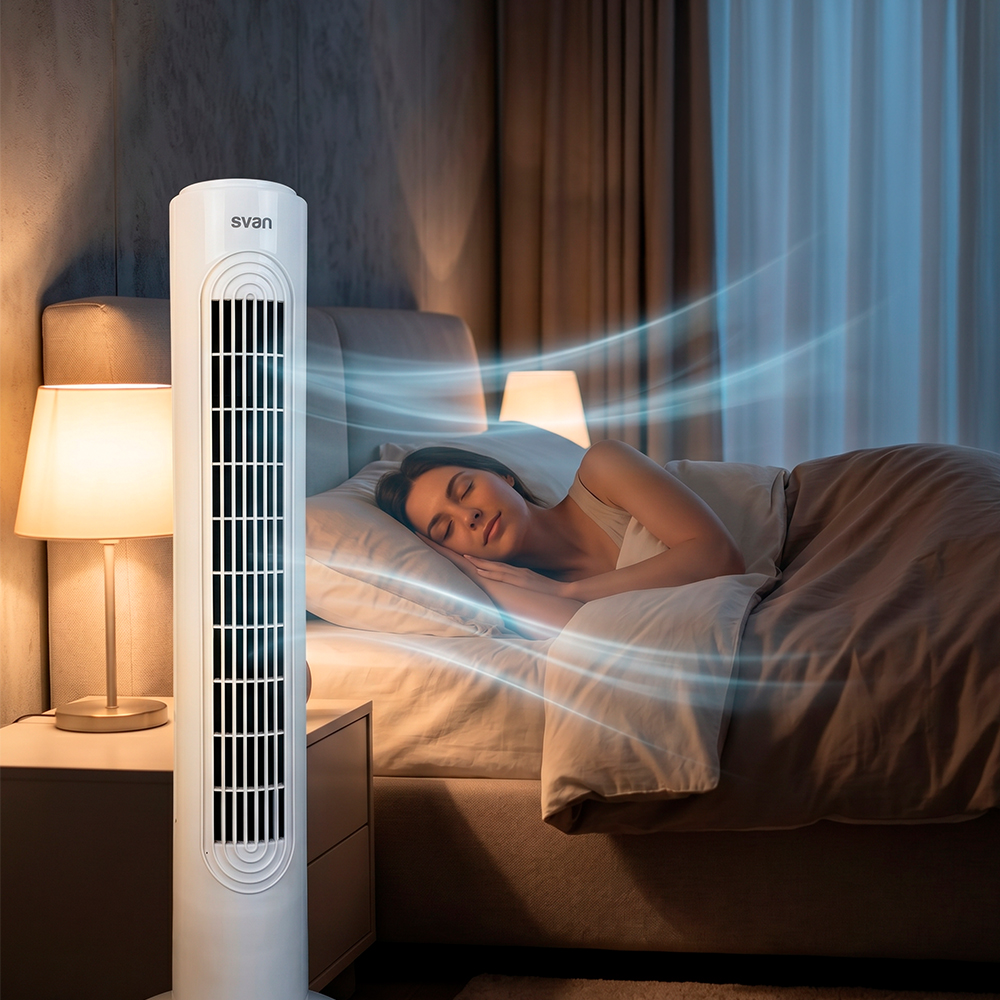 Un ventilador de torre blanco sopla suaves corrientes de aire azul hacia una mujer durmiendo en la cama.