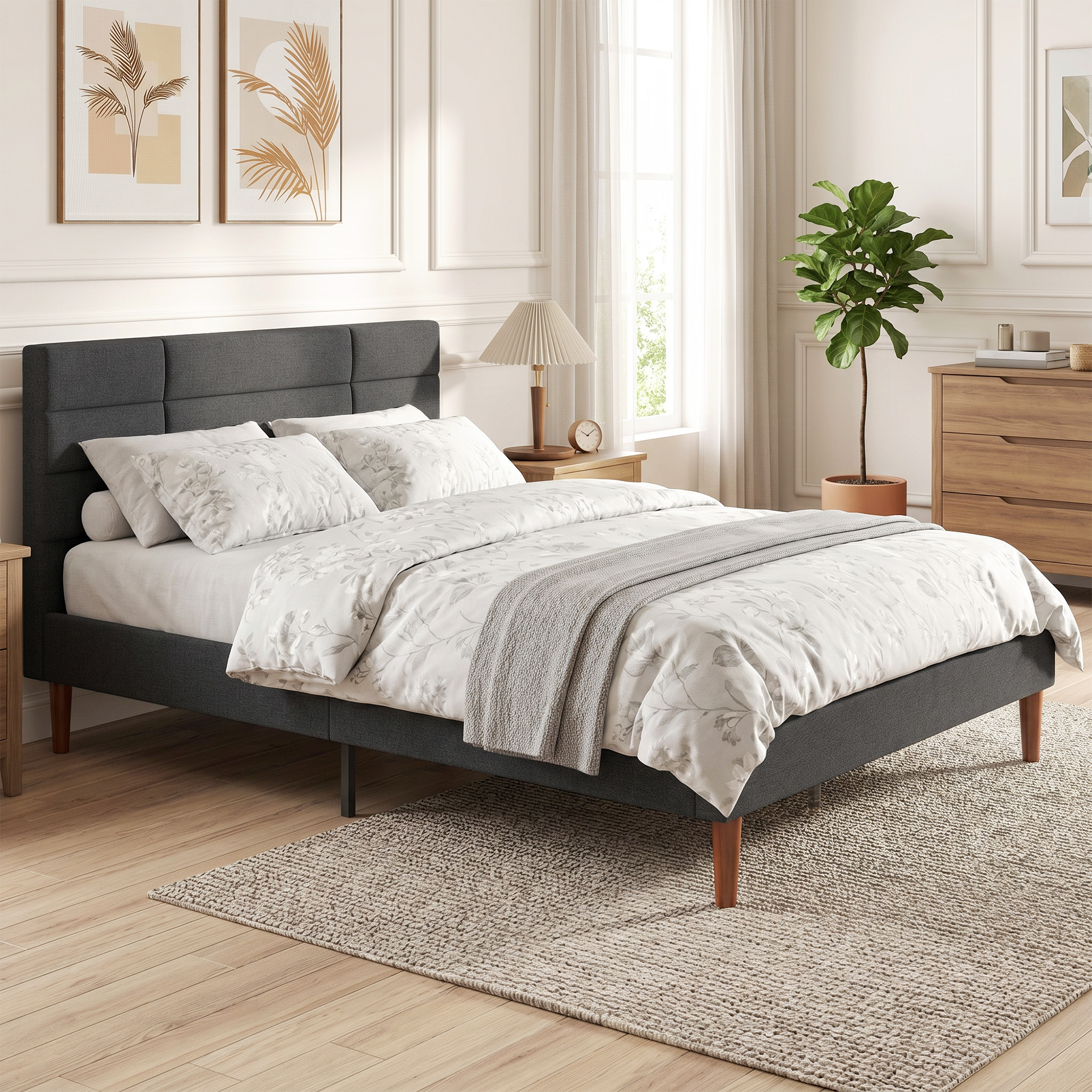 Una cama tapizada gris moderna con ropa de cama floral se encuentra sobre una alfombra en un dormitorio.