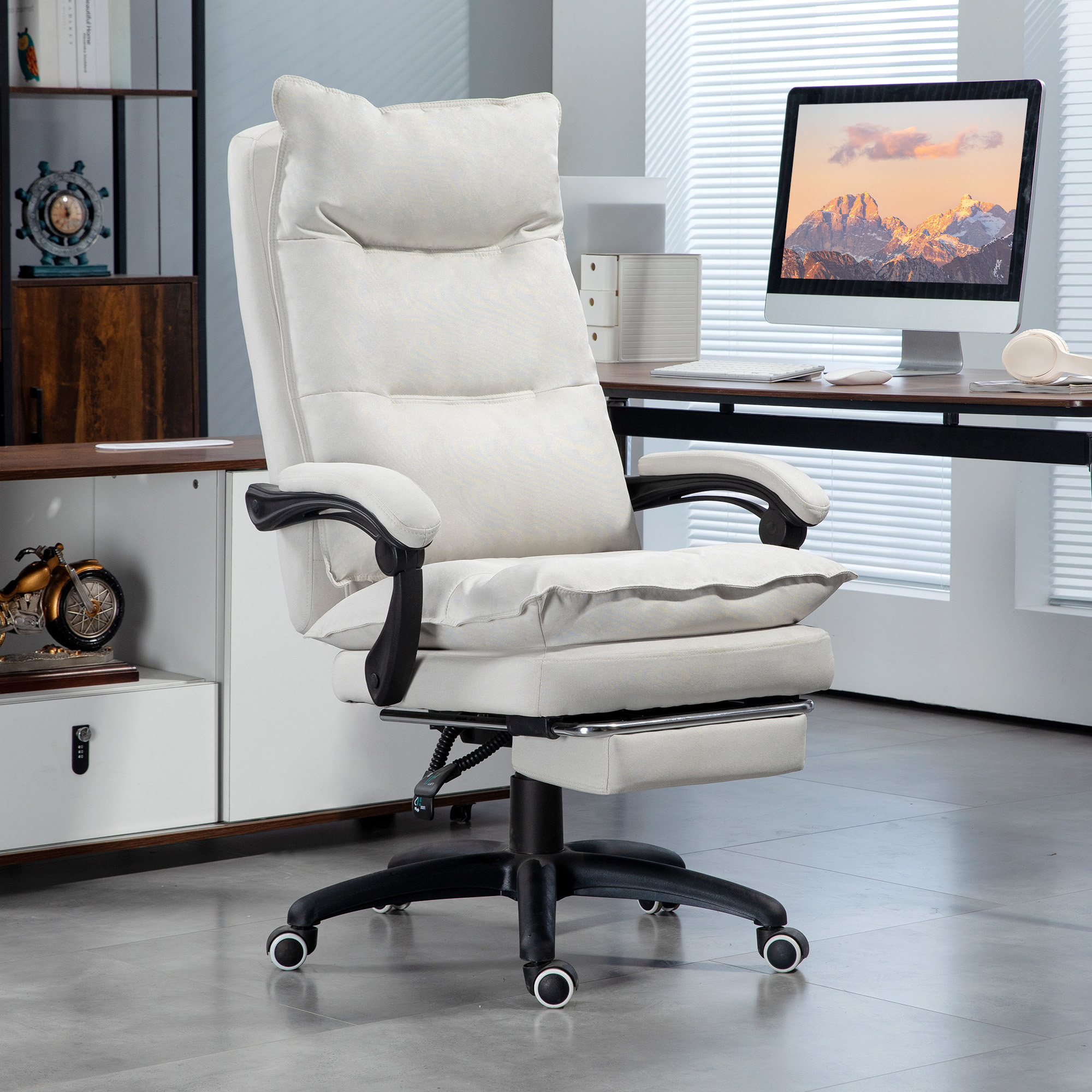 Una silla de oficina acolchada blanca con reposacabezas y reposapiés extraíble en una oficina moderna.