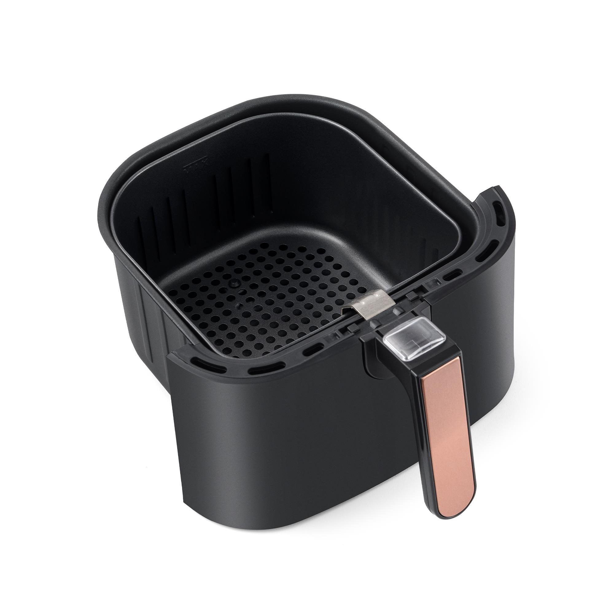 Beyaz arka planda pembe altın kulplu siyah airfryer sepeti.