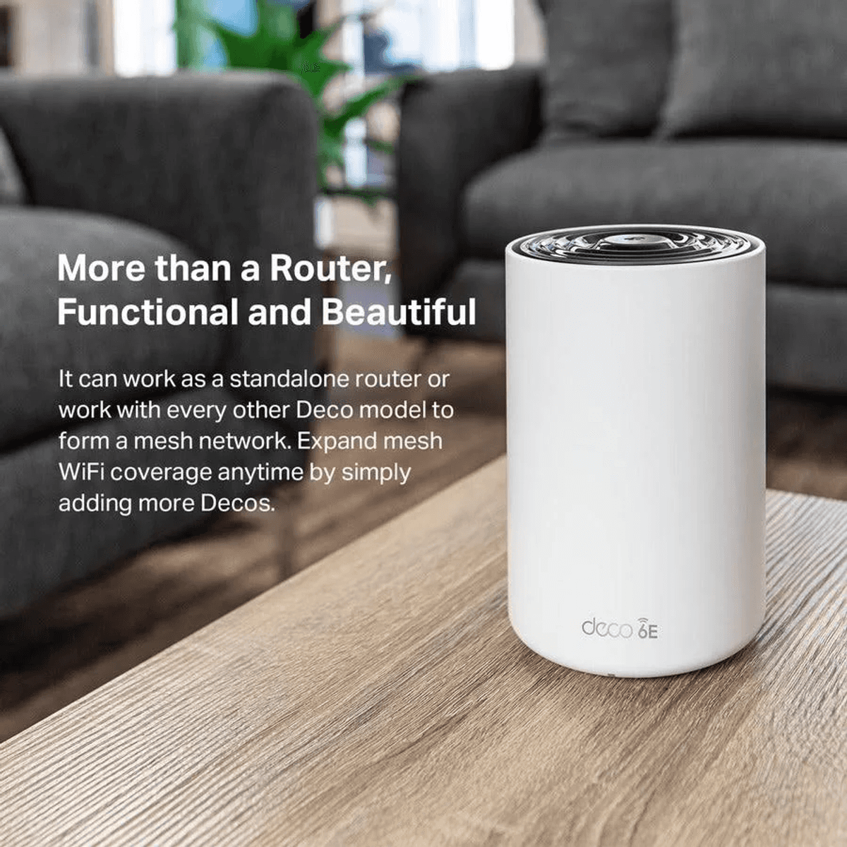 Ein weißer, zylindrischer Deco 6E Mesh-Router steht auf einem Holztisch in einem Wohnzimmer mit Werbetext.