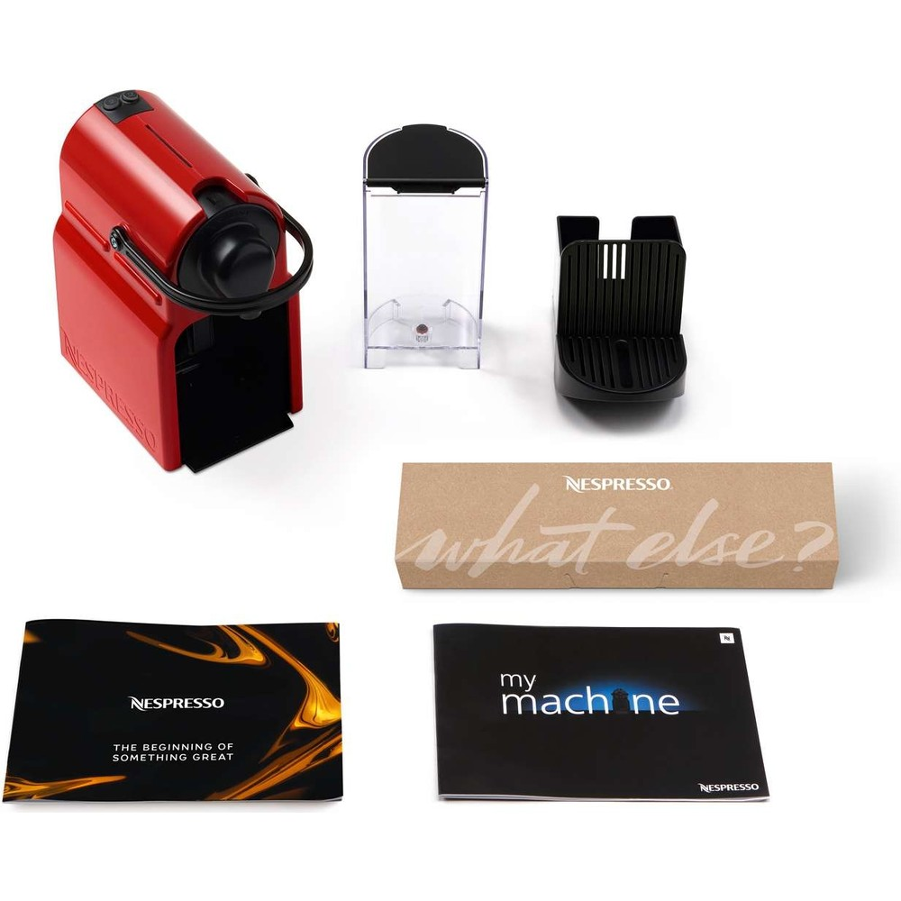 Çıkarılabilir su haznesi, kapsül tutucu, karton kutu ve iki kullanım kılavuzu olan kırmızı Nespresso kahve makinesi.