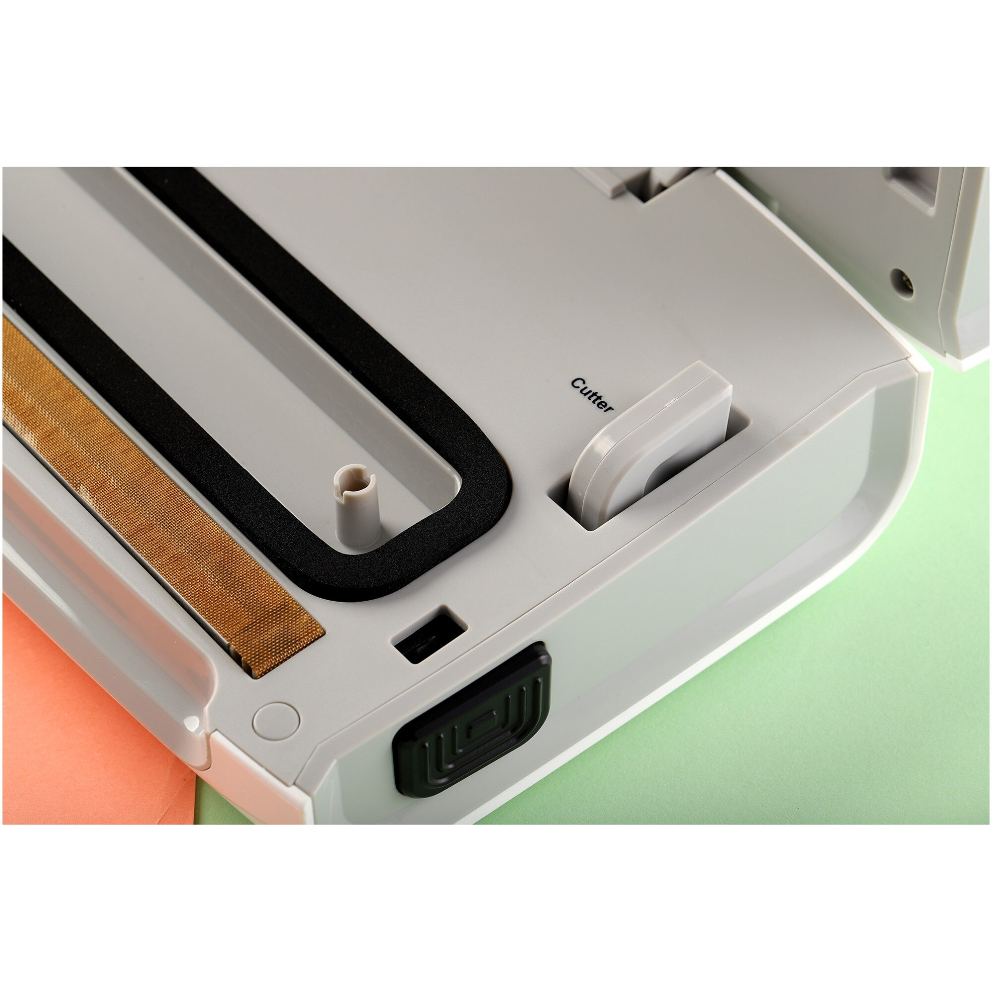 Vue intérieure d'une machine à emballer sous vide avec fil chauffant jaune, joint noir et cutter.