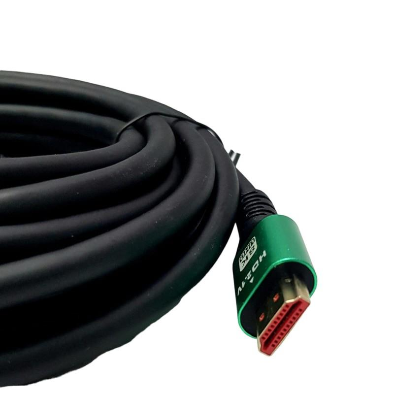 Beyaz arka planda yeşil metal konektörlü ve altın pimli siyah sarılmış bir HDMI kablosu.