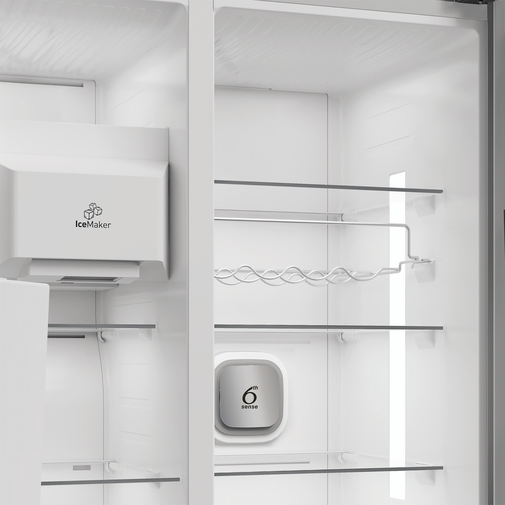 Interior de un refrigerador blanco vacío con estantes de vidrio, fabricador de hielo y logo 6th Sense.