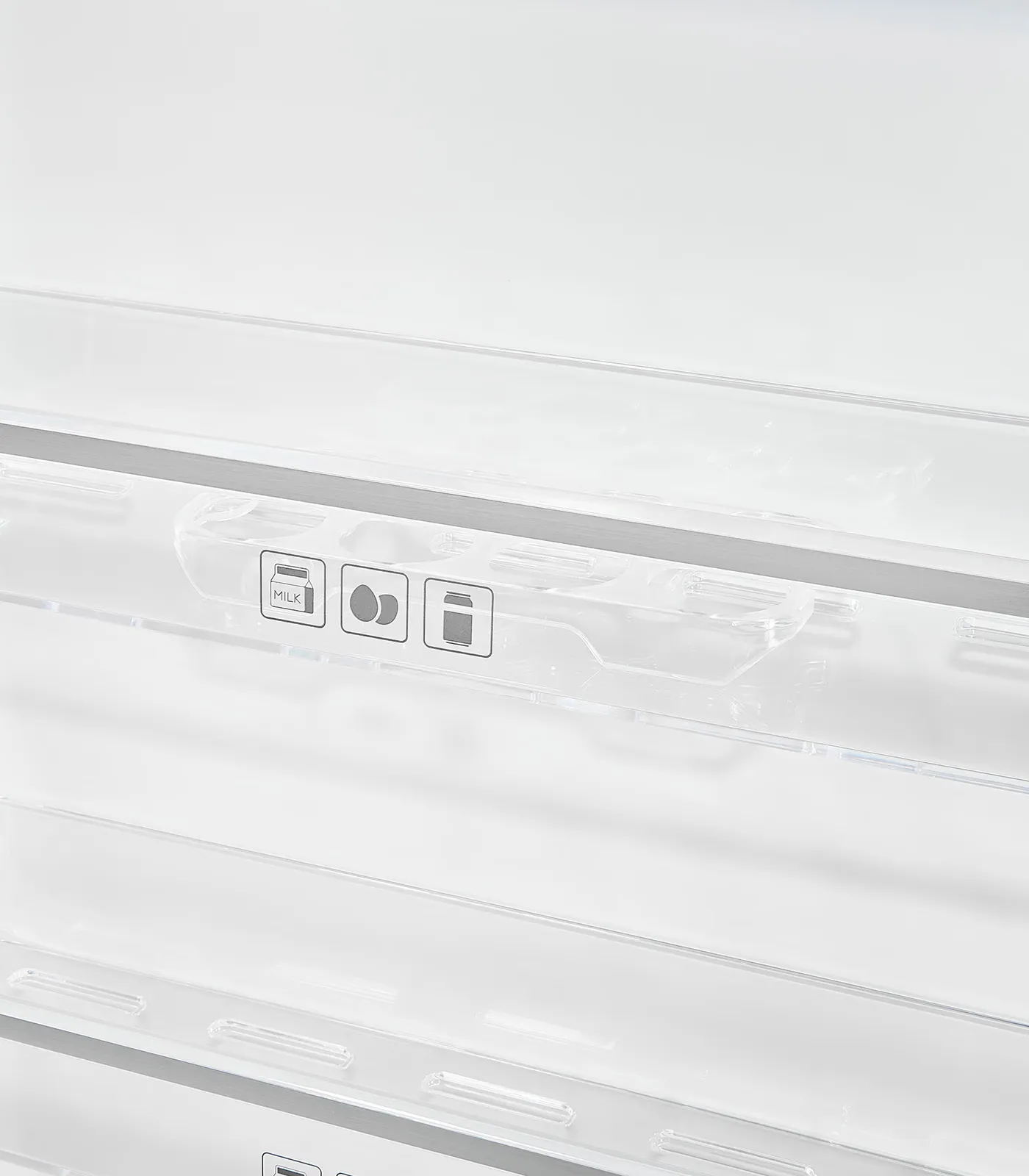 Nahaufnahme eines transparenten Kühlschranktürregals aus Kunststoff mit drei Lebensmittelsymbolen.