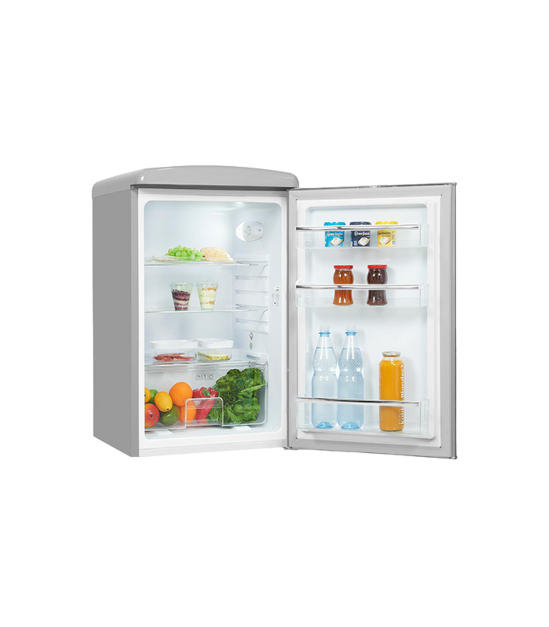 Un pequeño refrigerador plateado con la puerta abierta, lleno de frutas, verduras, botellas y yogur.