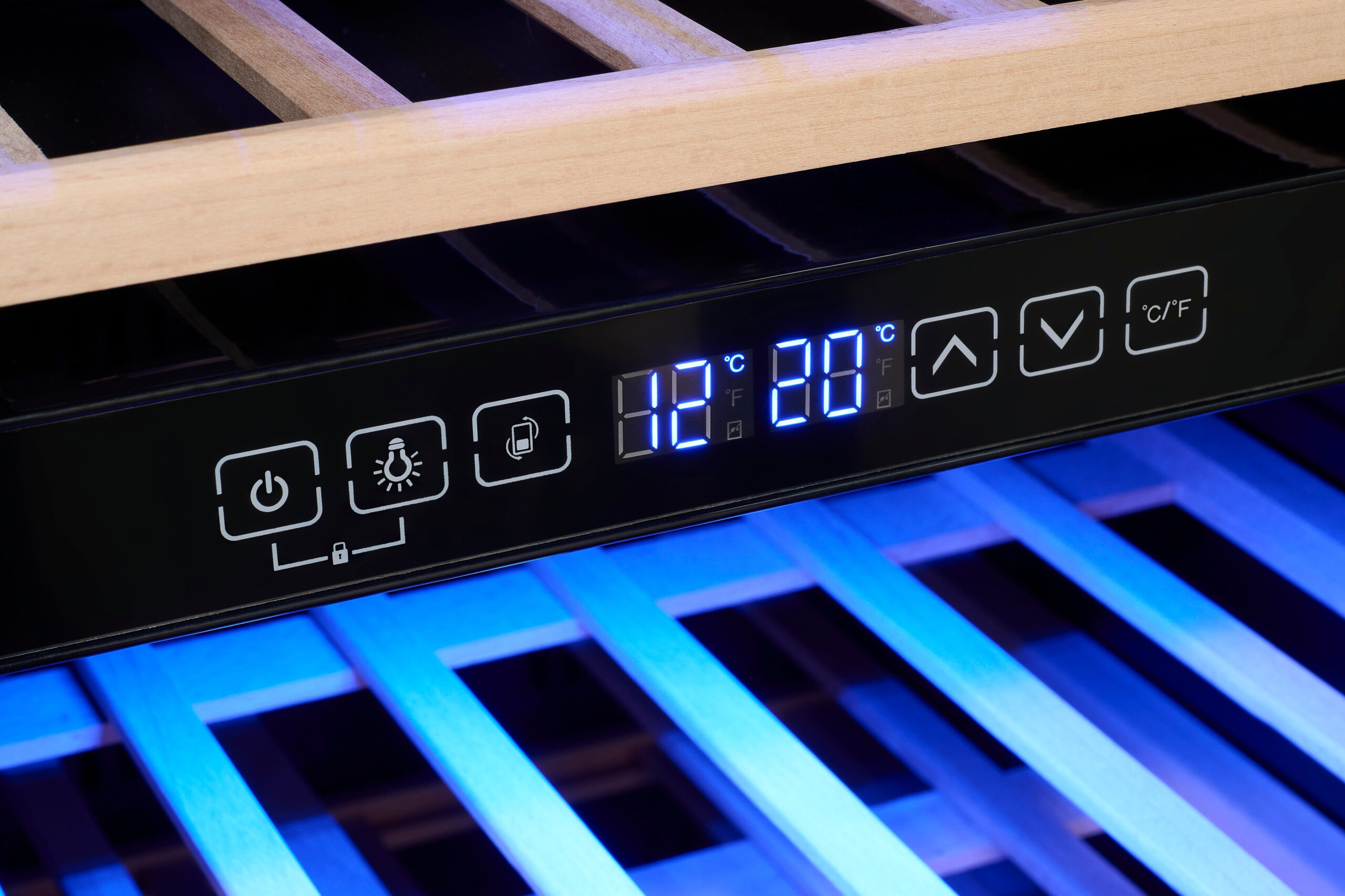 Panel de control de una vinoteca con pantalla digital LED azul, botones táctiles y estantes de madera con luz azul.