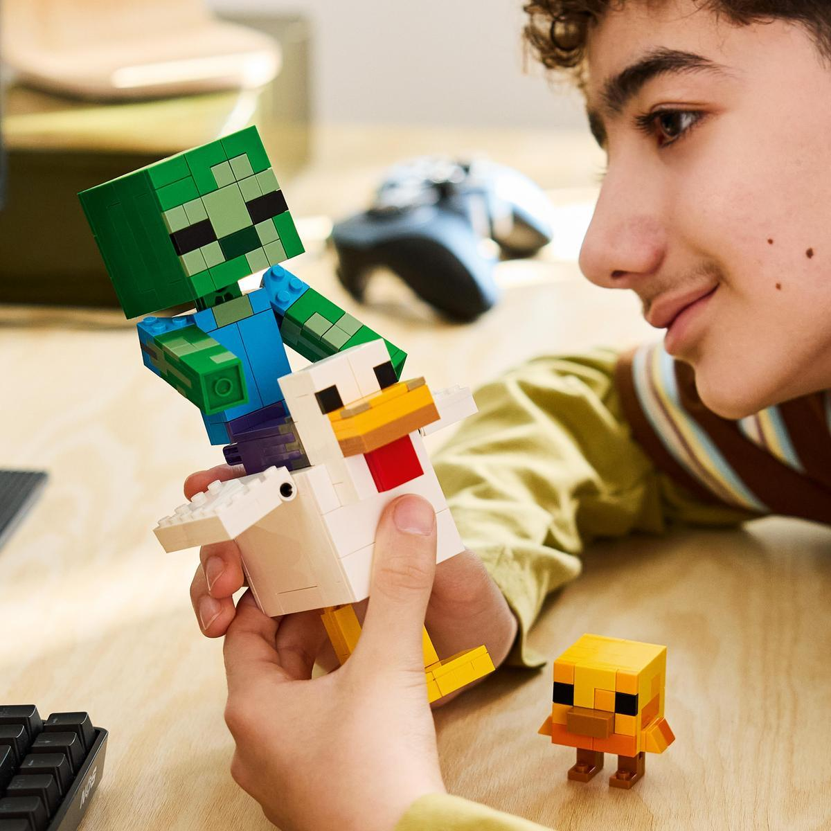 Un chico mira un modelo de Lego de Minecraft de un zombi montando un pollo.