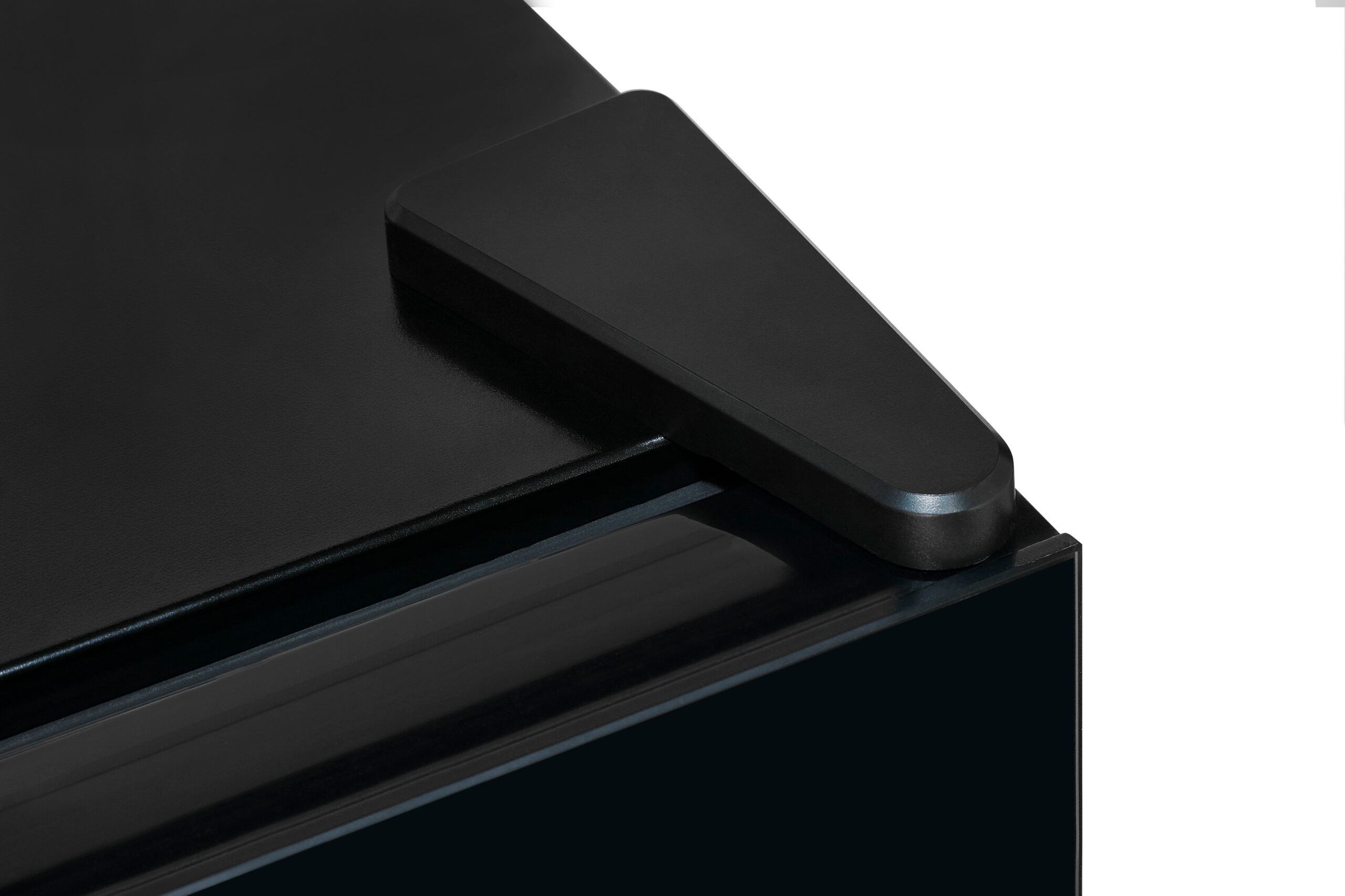 Primer plano de una esquina de mueble negra con una pieza protectora triangular.
