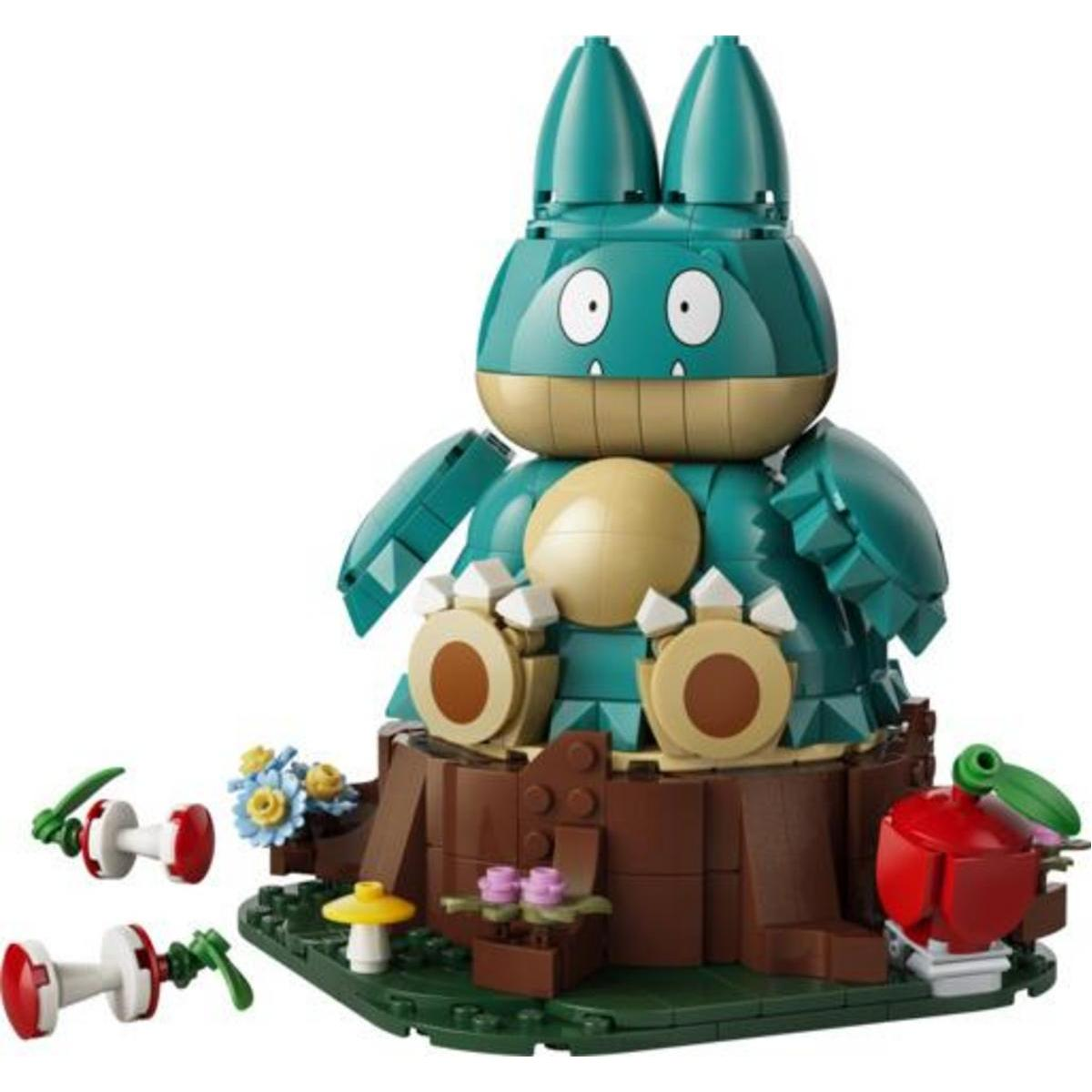 Un modelo de LEGO verde y beige de un gran personaje Pokémon sentado en un tronco, con pequeños hongos y flores cerca.