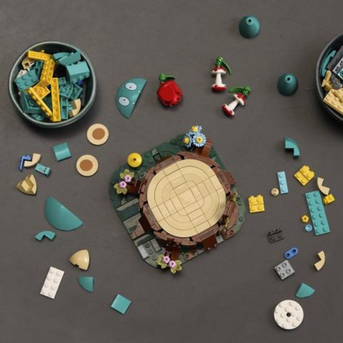 Varias piezas de Lego y un modelo de Lego parcialmente construido en una superficie oscura.