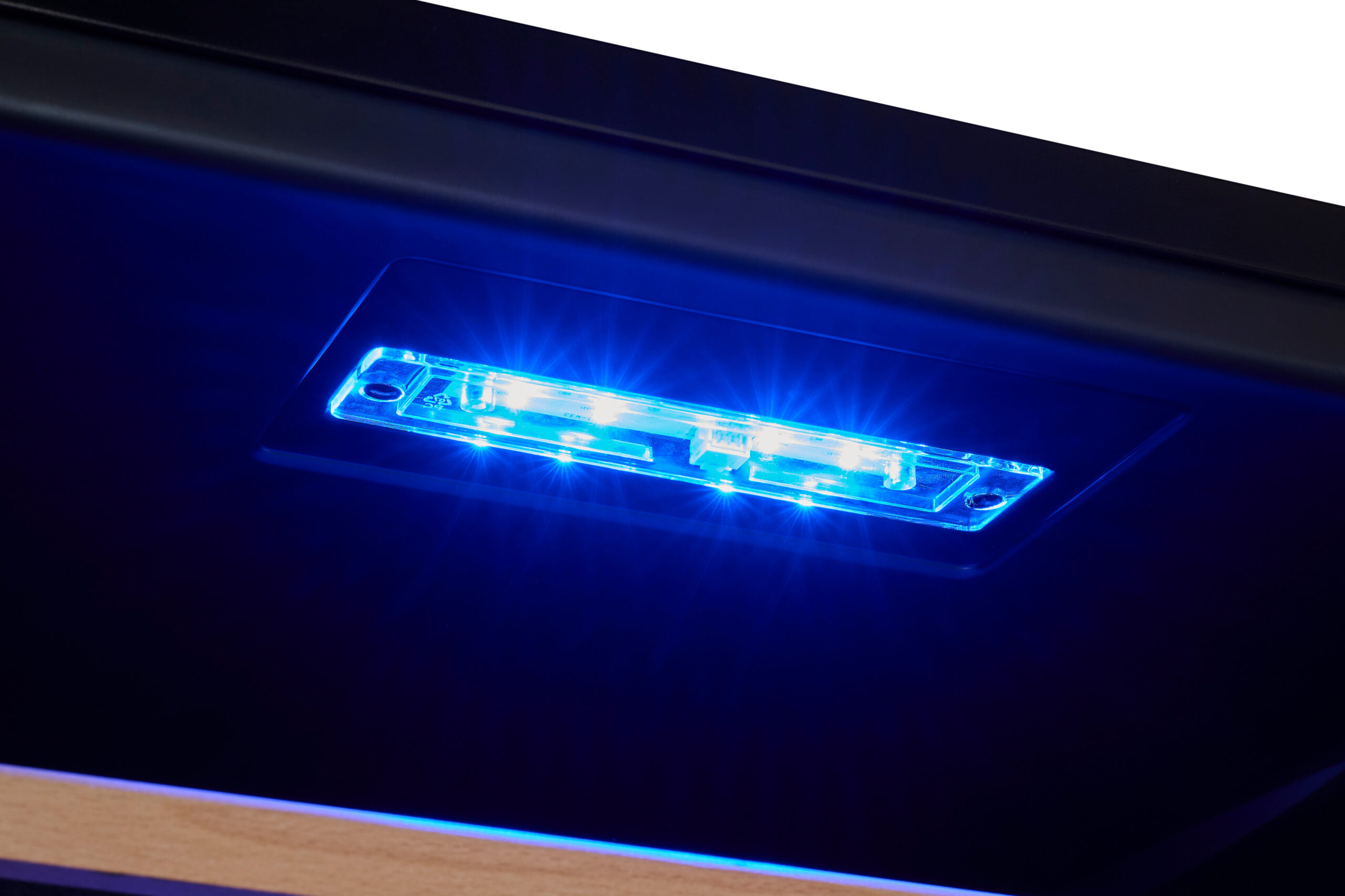 Una luz LED azul brillante incrustada en una superficie oscura con un acento de madera.