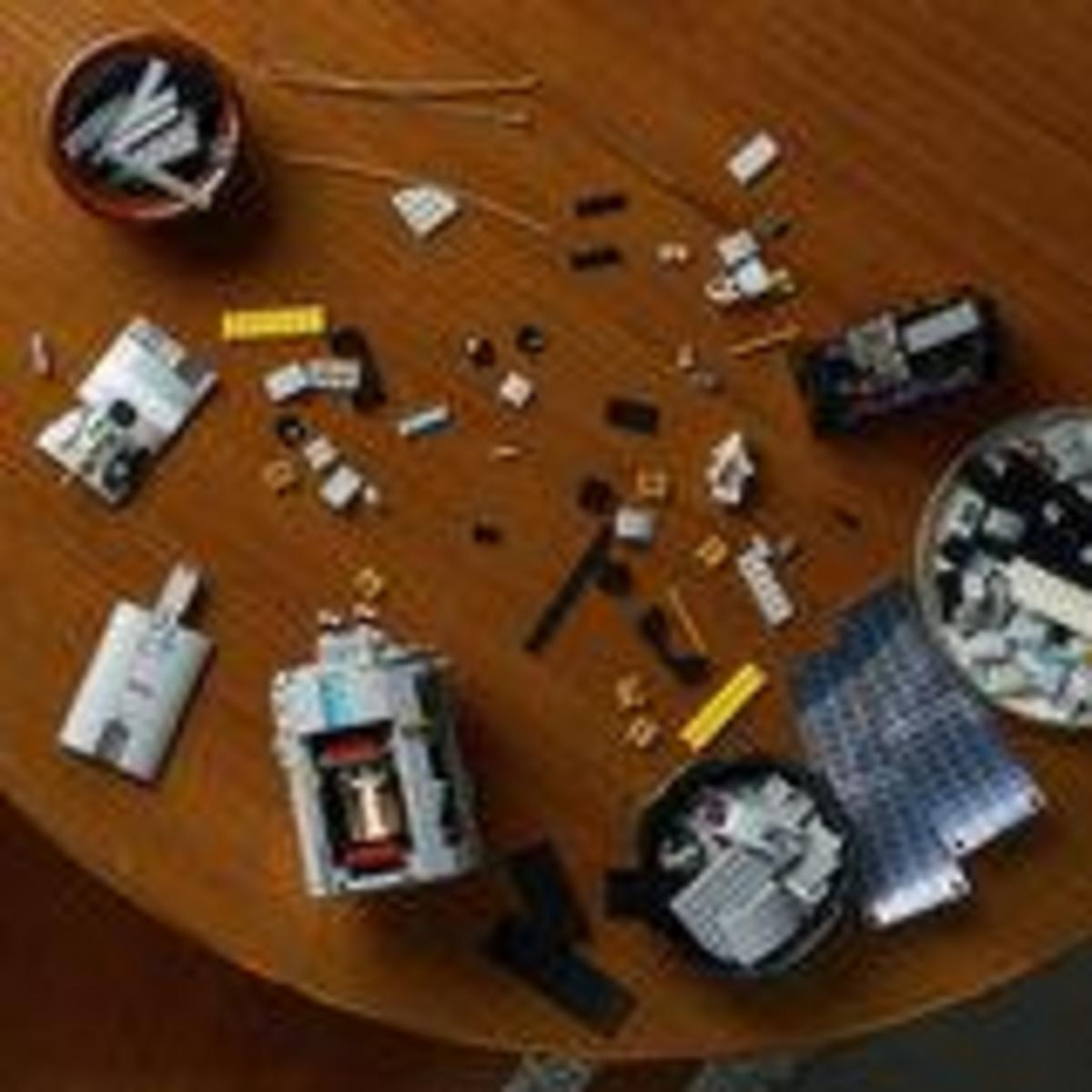 Vista cenital de piezas de Lego y cuencos esparcidos en una mesa de madera.