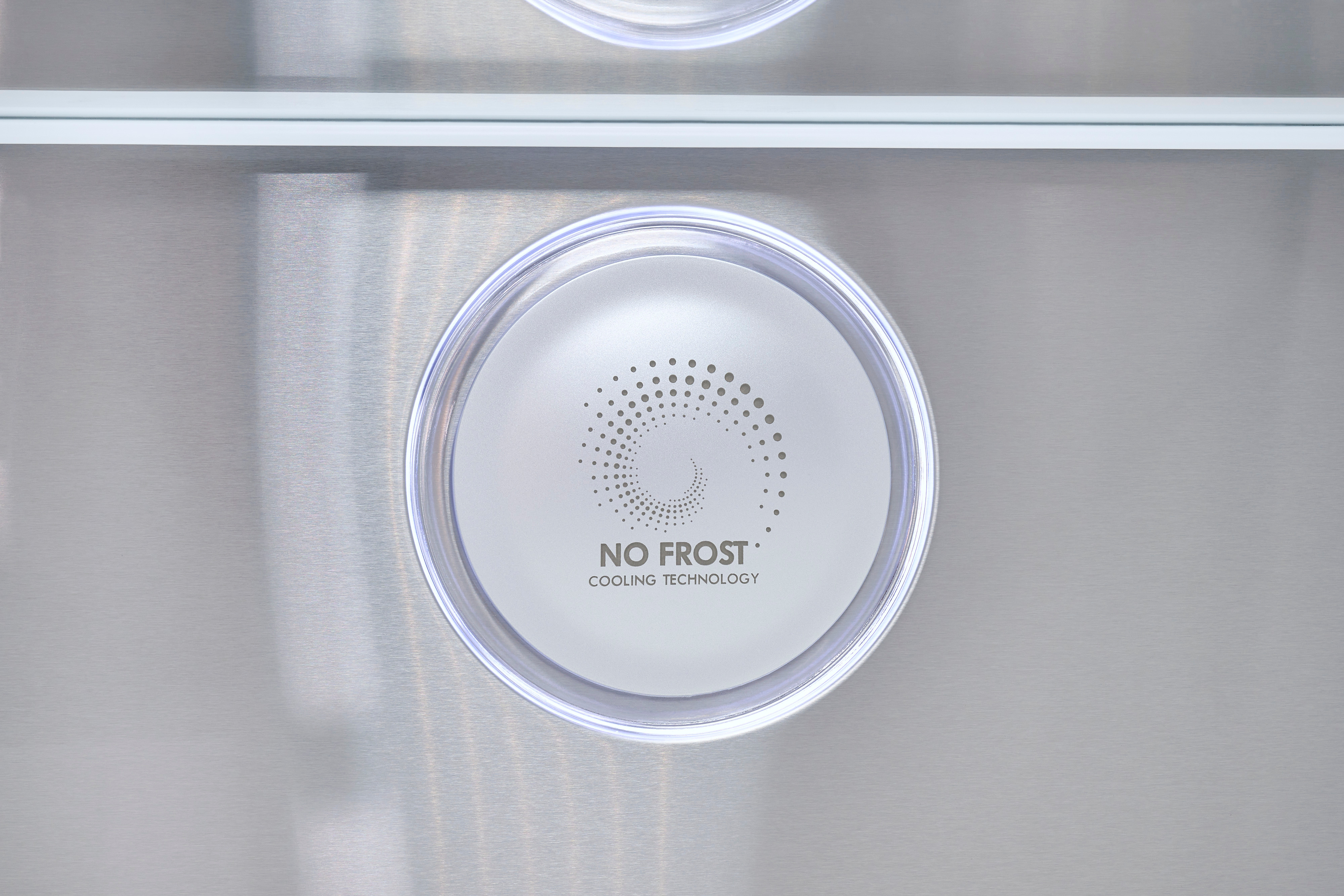 Nahaufnahme einer runden Anzeige mit der Aufschrift 'NO FROST COOLING TECHNOLOGY' auf gebürstetem Edelstahl.