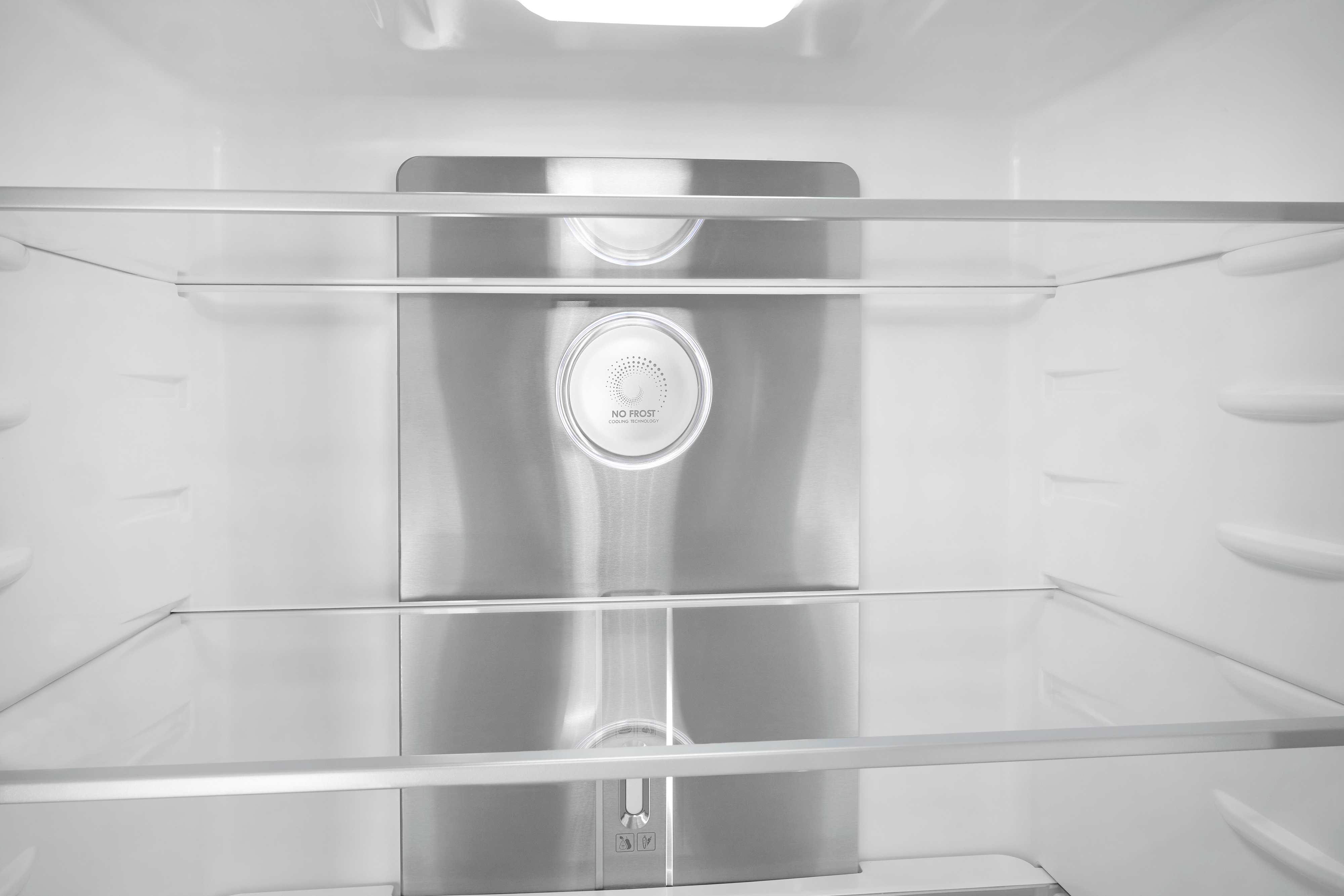 Leerer, sauberer Kühlschrankinnenraum mit Glasregalen und No-Frost-Metallrückwand.