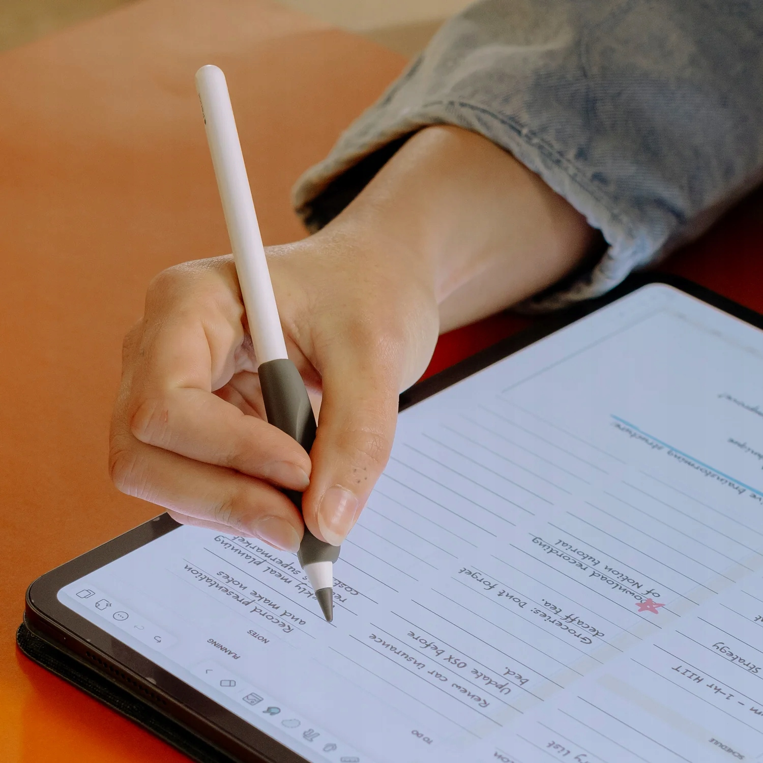 Qualcuno scrive con un pennino su un tablet che mostra una lista di cose da fare.