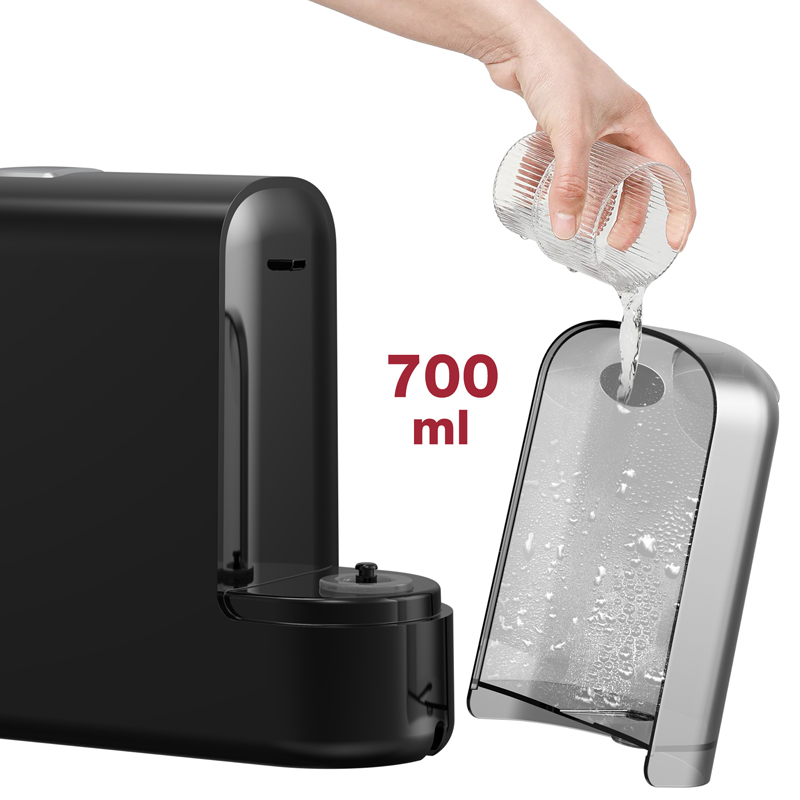 Una mano versa acqua da un bicchiere nel serbatoio dell'acqua da 700 ml di una macchina da caffè nera.