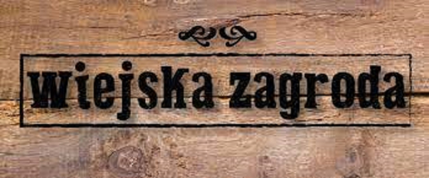 El texto Wiejska Zagroda en un marco negro sobre madera marrón.