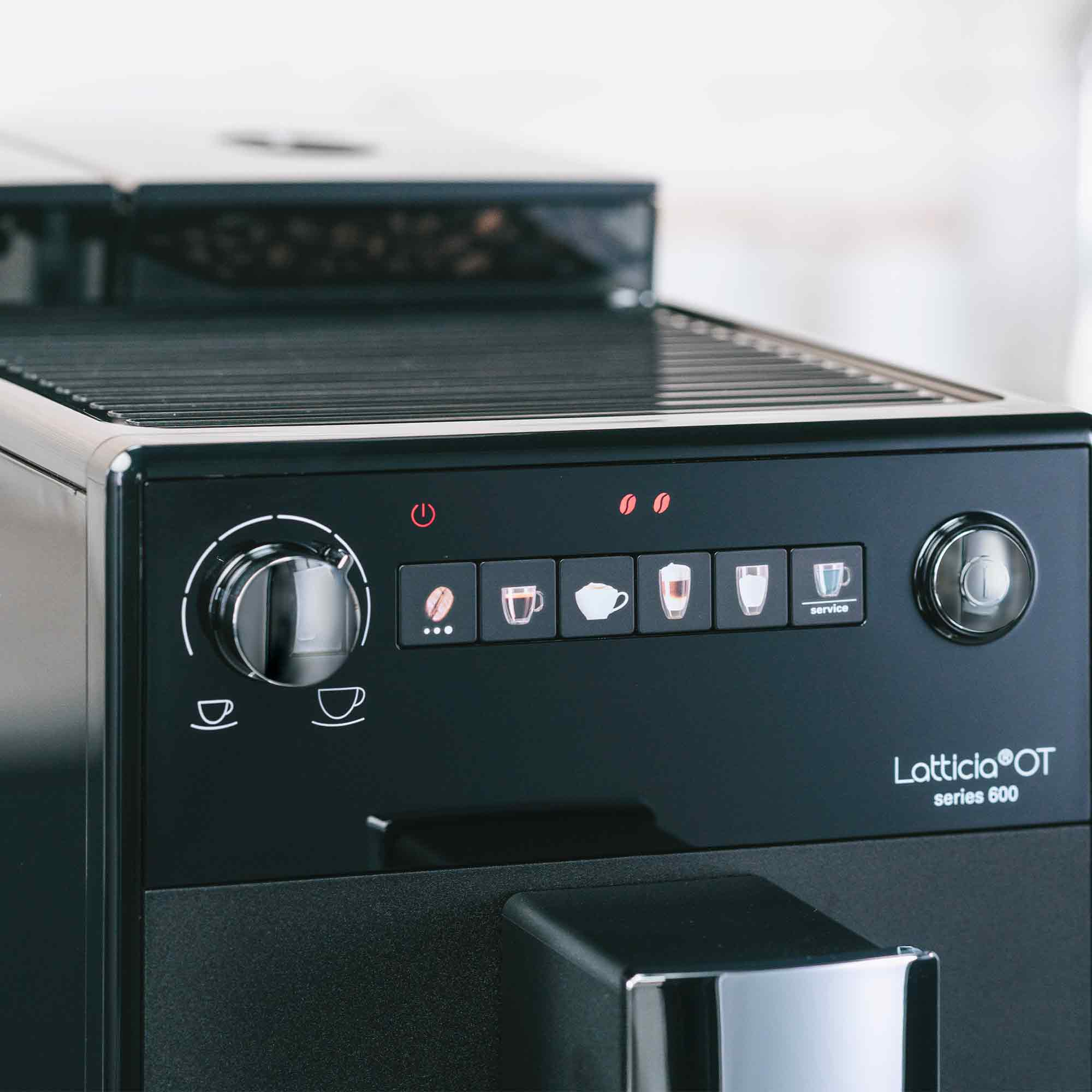 Primo piano del pannello di controllo di una macchina da caffè nera Latticia OT serie 600 con pulsanti e manopola.
