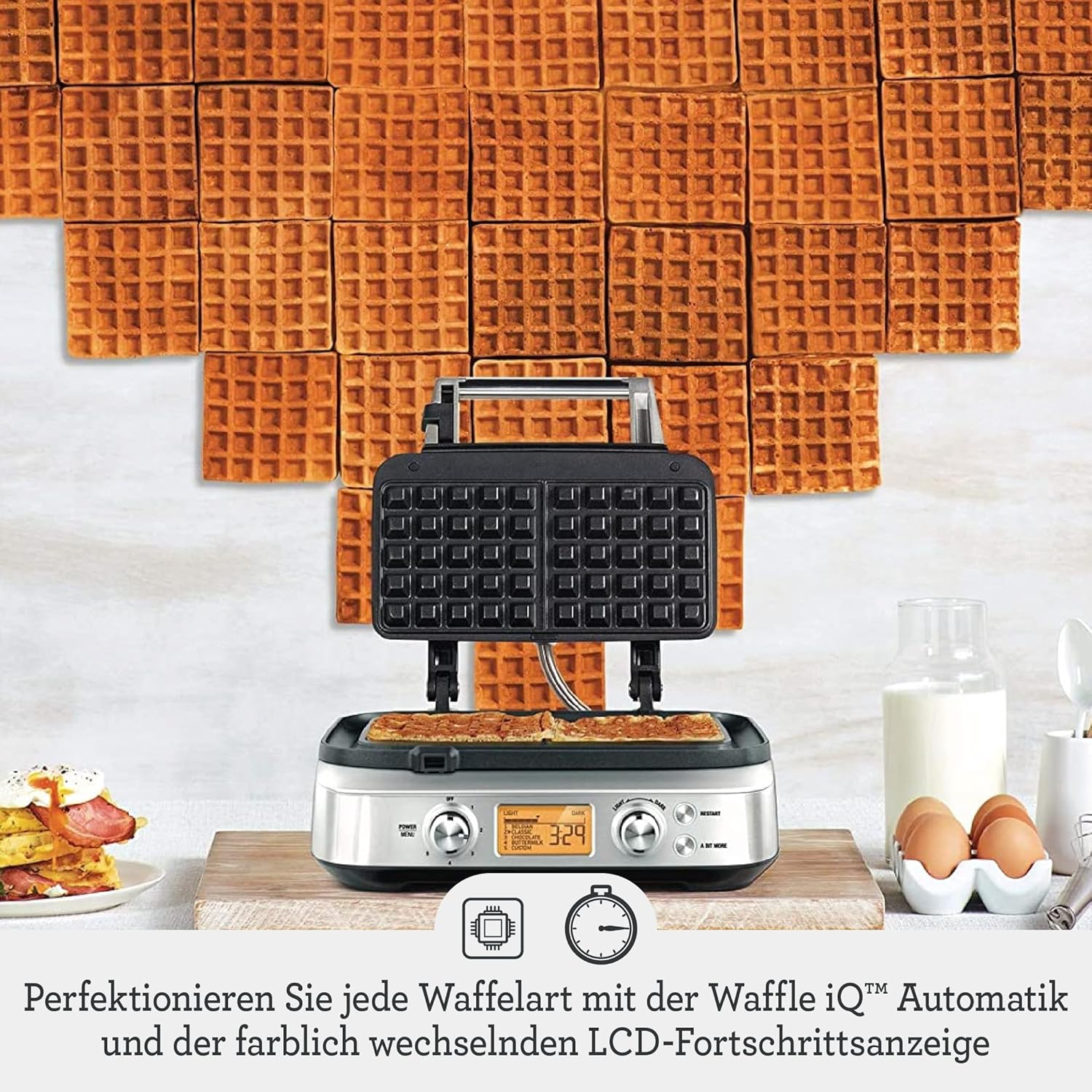 Piastra per waffle in acciaio inox su tagliere, con waffle, uova e latte. Sfondo con motivo a waffle.