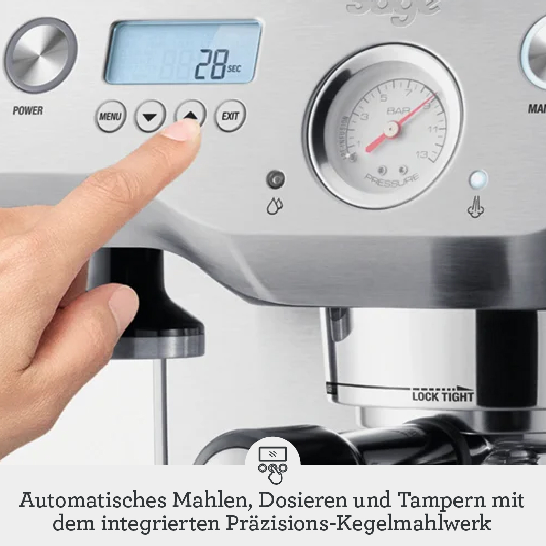 Una mano aziona il display digitale di una macchina da caffè argentata con manometro.