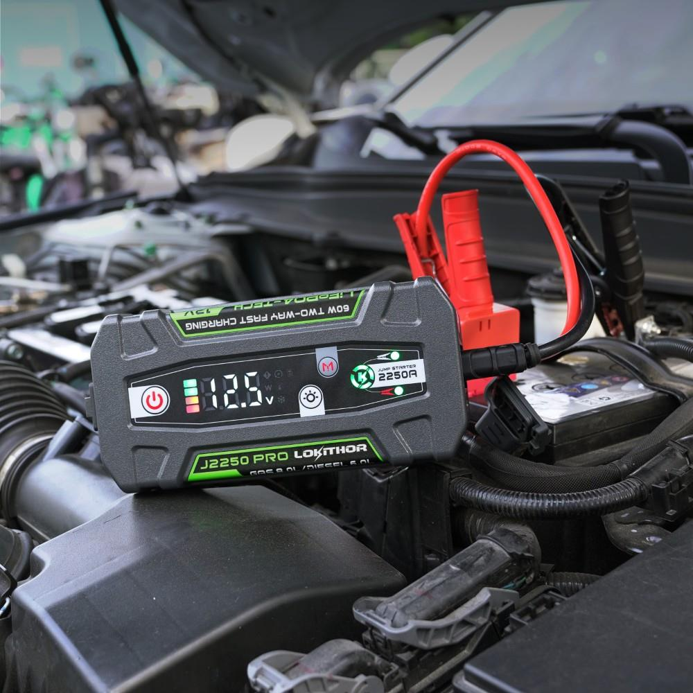 Kırmızı kabloları bağlı bir araba motoru üzerinde Lokithor J2250 Pro takviye cihazı.