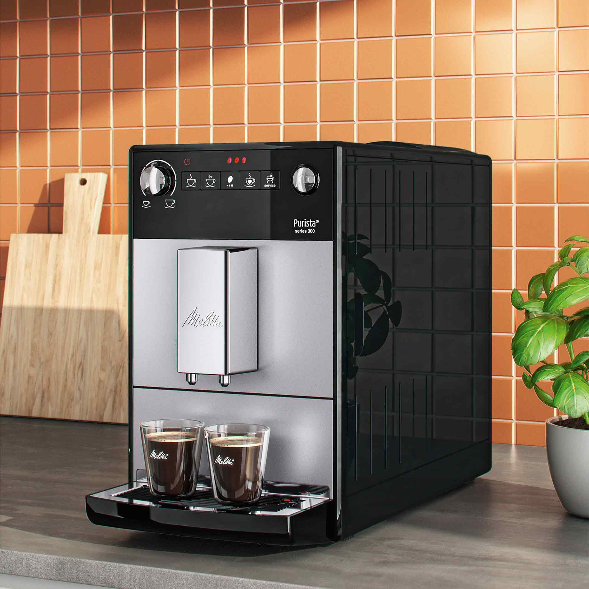 Een zwart-zilveren Melitta Purista koffiemachine op een aanrecht met twee gevulde glazen.