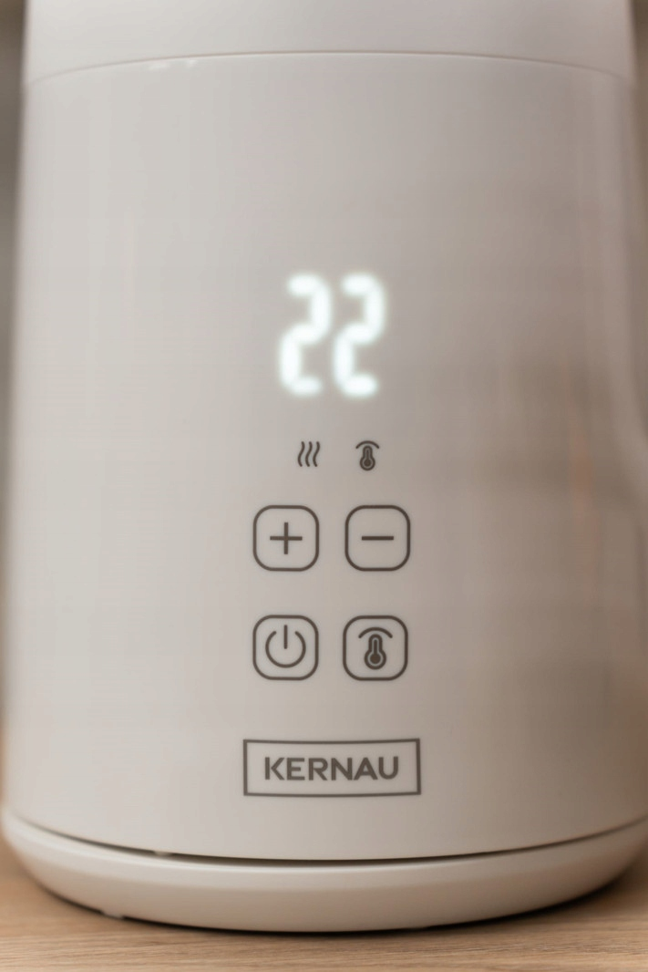 Biały czajnik elektryczny z cyfrowym wyświetlaczem temperatury wskazującym 22, przyciskami plus i minus oraz logo Kernau.