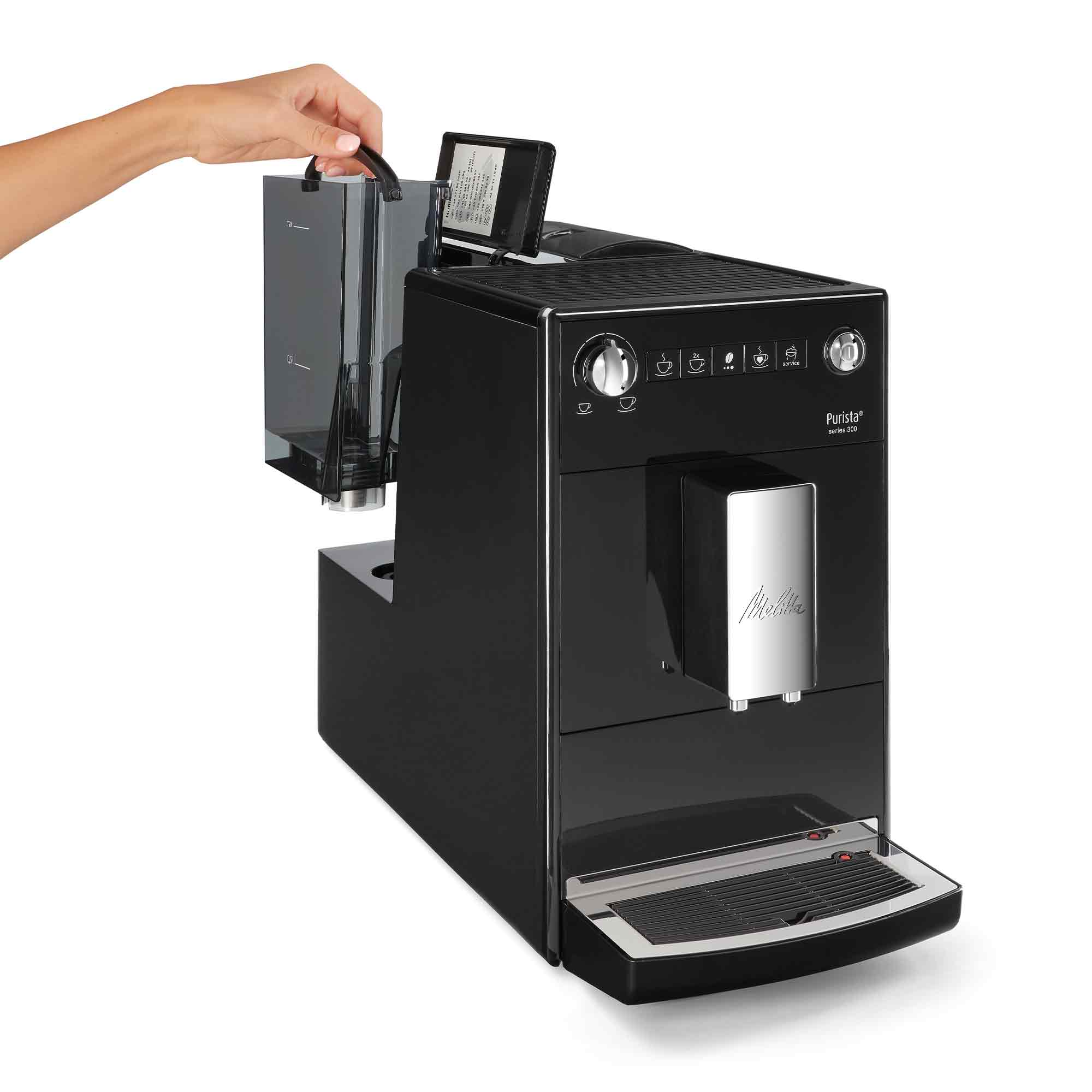 Una mano estrae il serbatoio dell'acqua da una macchina da caffè nera.