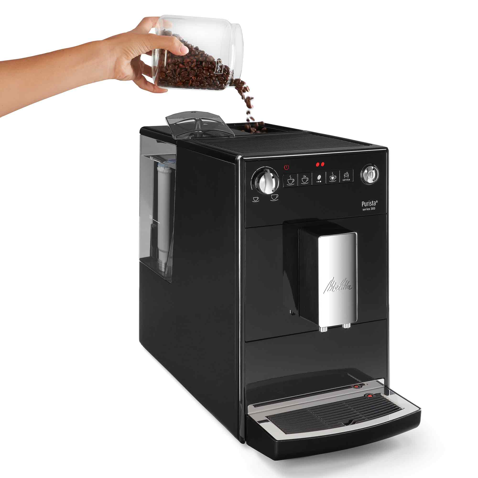 Una mano versa chicchi di caffè da un barattolo nel serbatoio di una macchina da caffè nera Melitta Purista.
