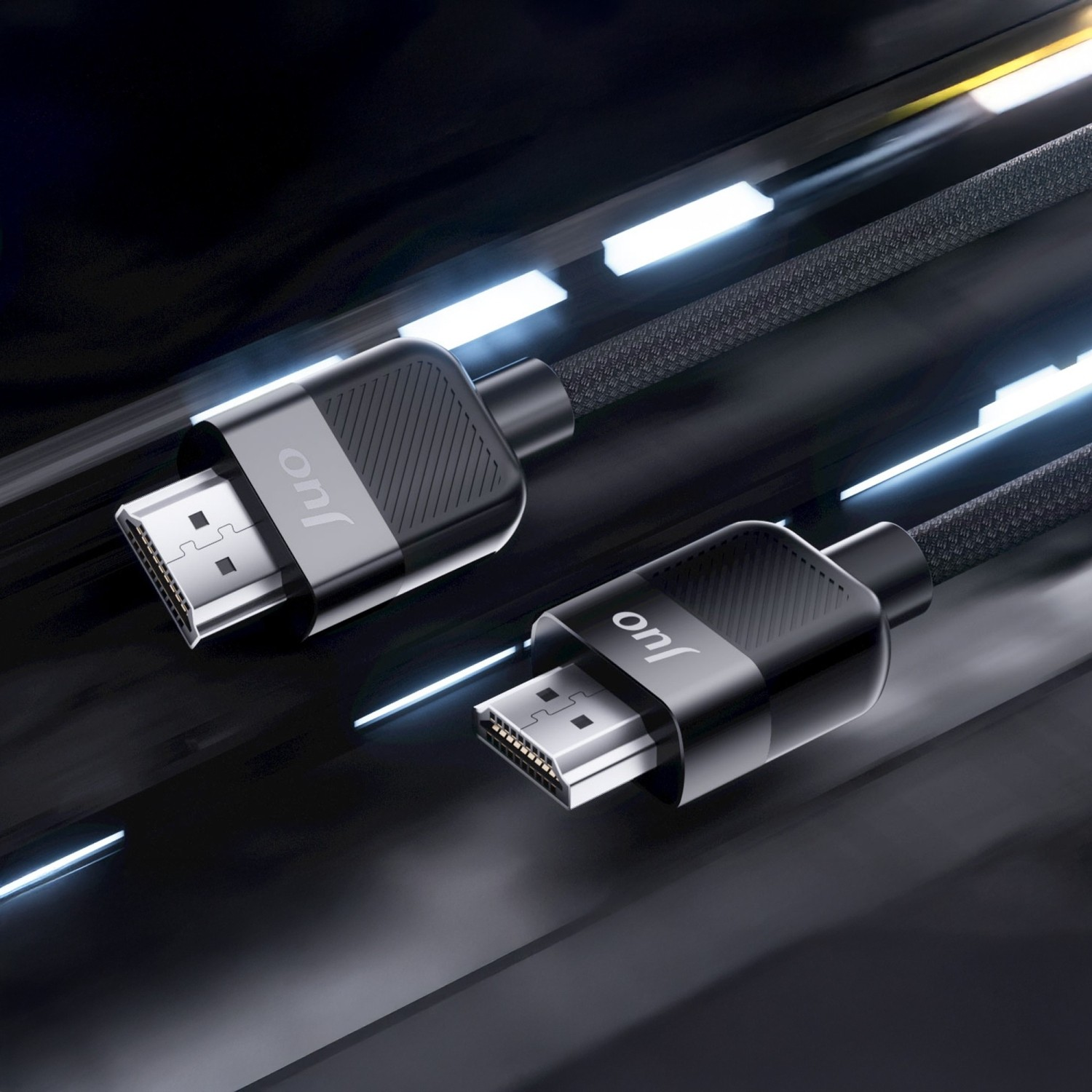 Metal konnektörlü iki siyah HDMI kablosu, mavi ışıklı parlak bir yüzey üzerinde duruyor.