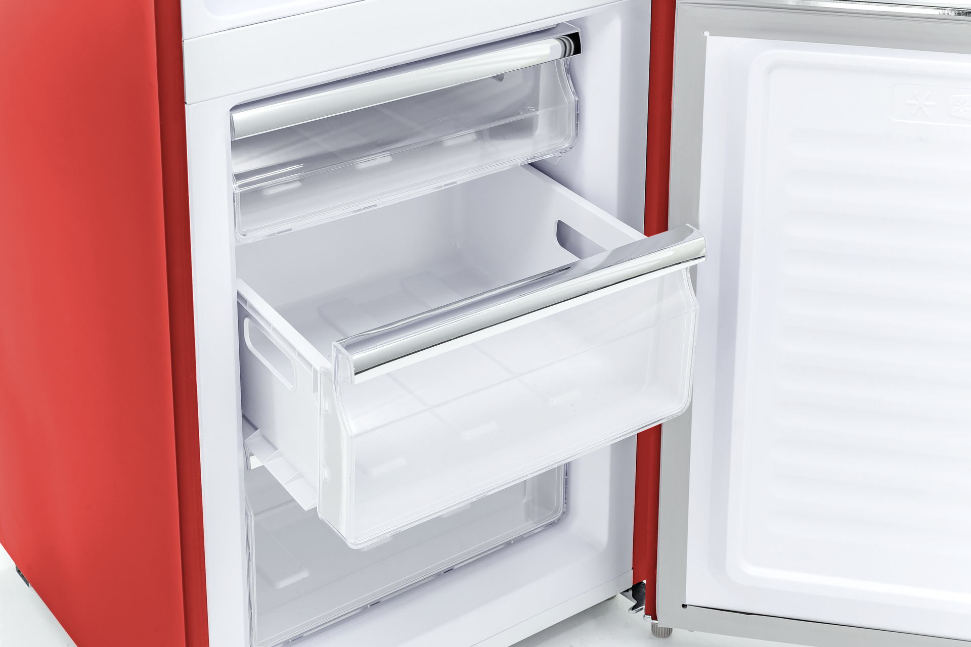 Offener roter Gefrierschrank mit transparenten Schubladen und silbernen Griffen.