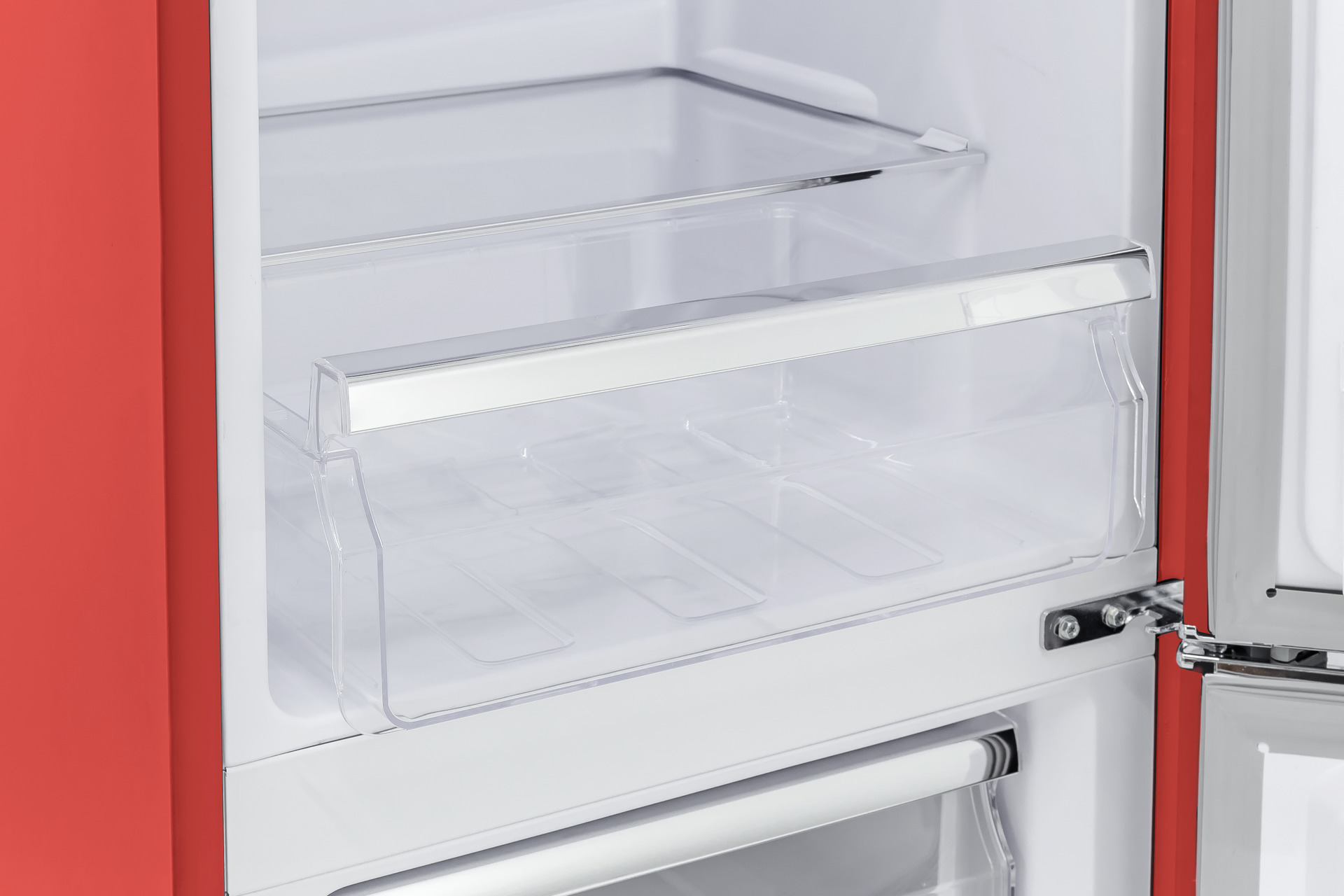 Geöffneter roter Kühlschrank mit durchsichtigen Schubladen und Regalen im Innenraum.
