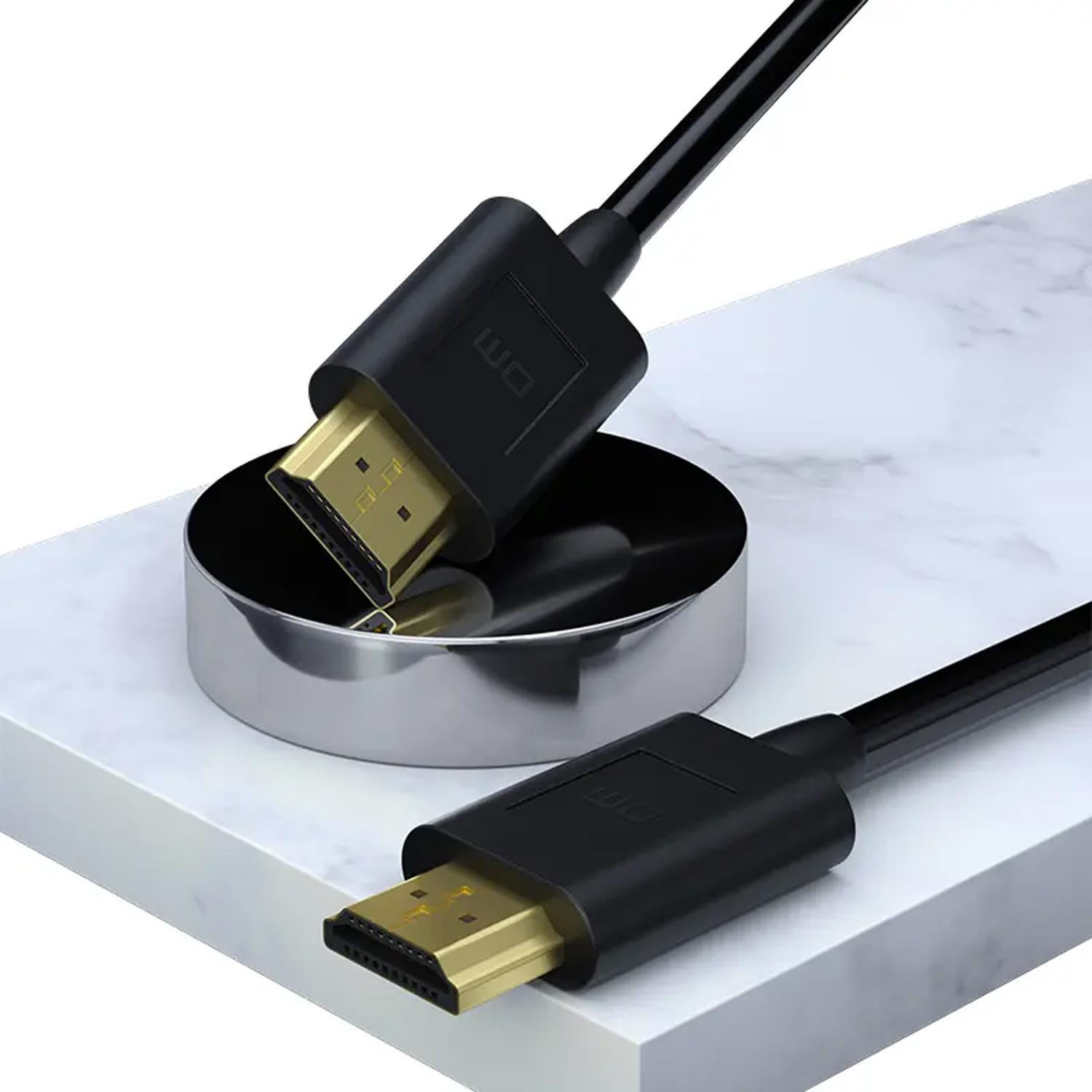 Altın konnektörlü iki siyah HDMI kablosu, gümüş rengi bir silindirin yanında beyaz mermer bir levha üzerinde duruyor.