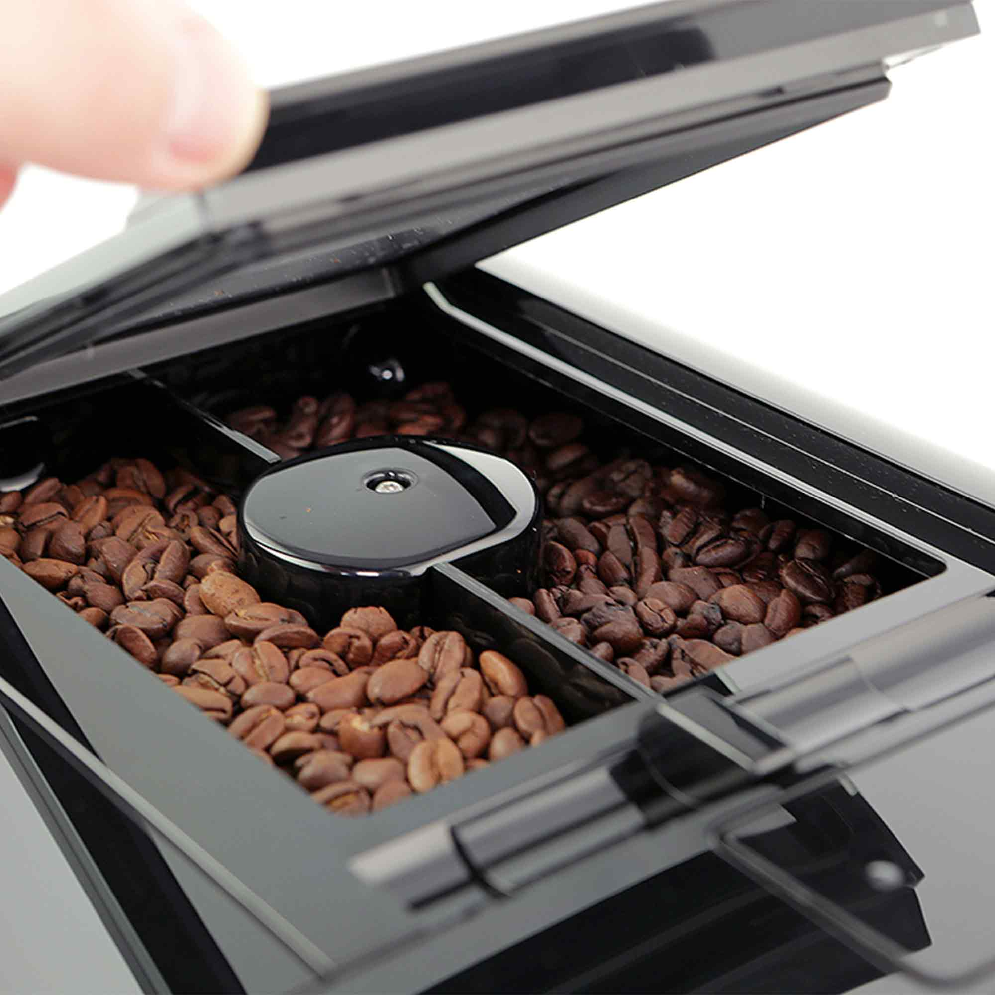 Eine geöffnete Kaffeemaschine zeigt frisch gefüllte, braune Kaffeebohnen im Behälter.