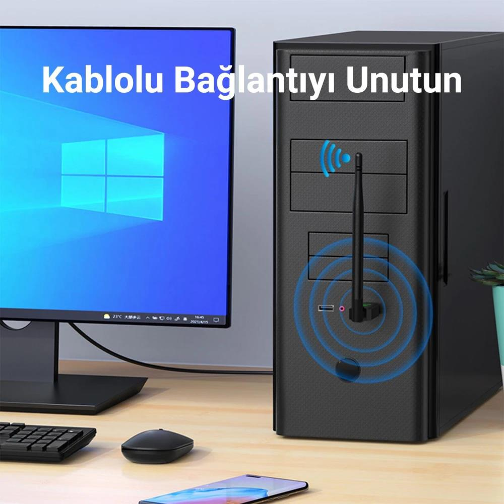 USB Wi-Fi adaptörlü masaüstü bilgisayar kasası, Windows ekranı, klavye, fare ve masada akıllı telefon.