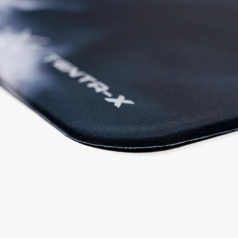 Siyah bir TENTA-X oyuncu mouse pad yüzeyinin dikişli kenarının yakın planı.