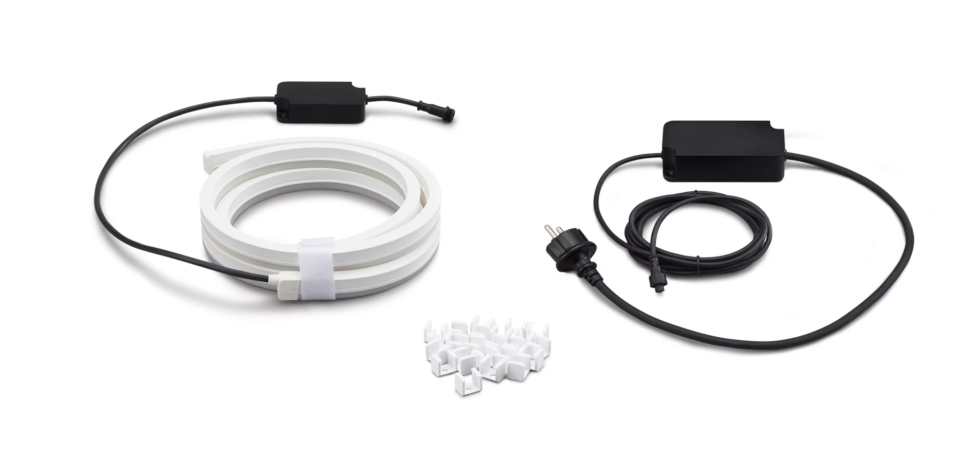 Un ruban LED blanc enroulé avec des câbles noirs, une alimentation, une prise et des clips de fixation.