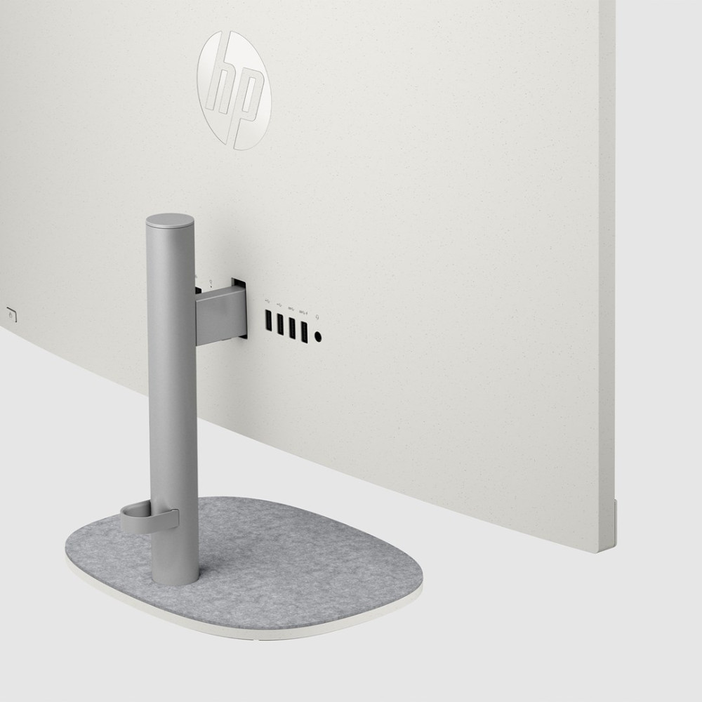 Widok z tyłu białego monitora HP ze srebrną podstawką, szarym filcowym spodem i portami USB na tylnym panelu.